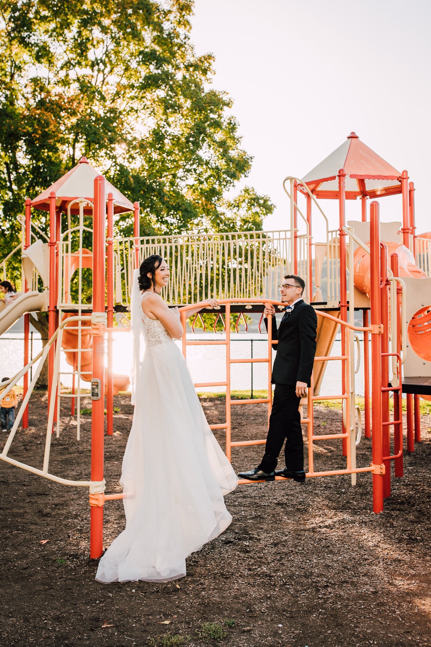  a bride and groom share a moment on a playground in the park before their hudson river wedding 