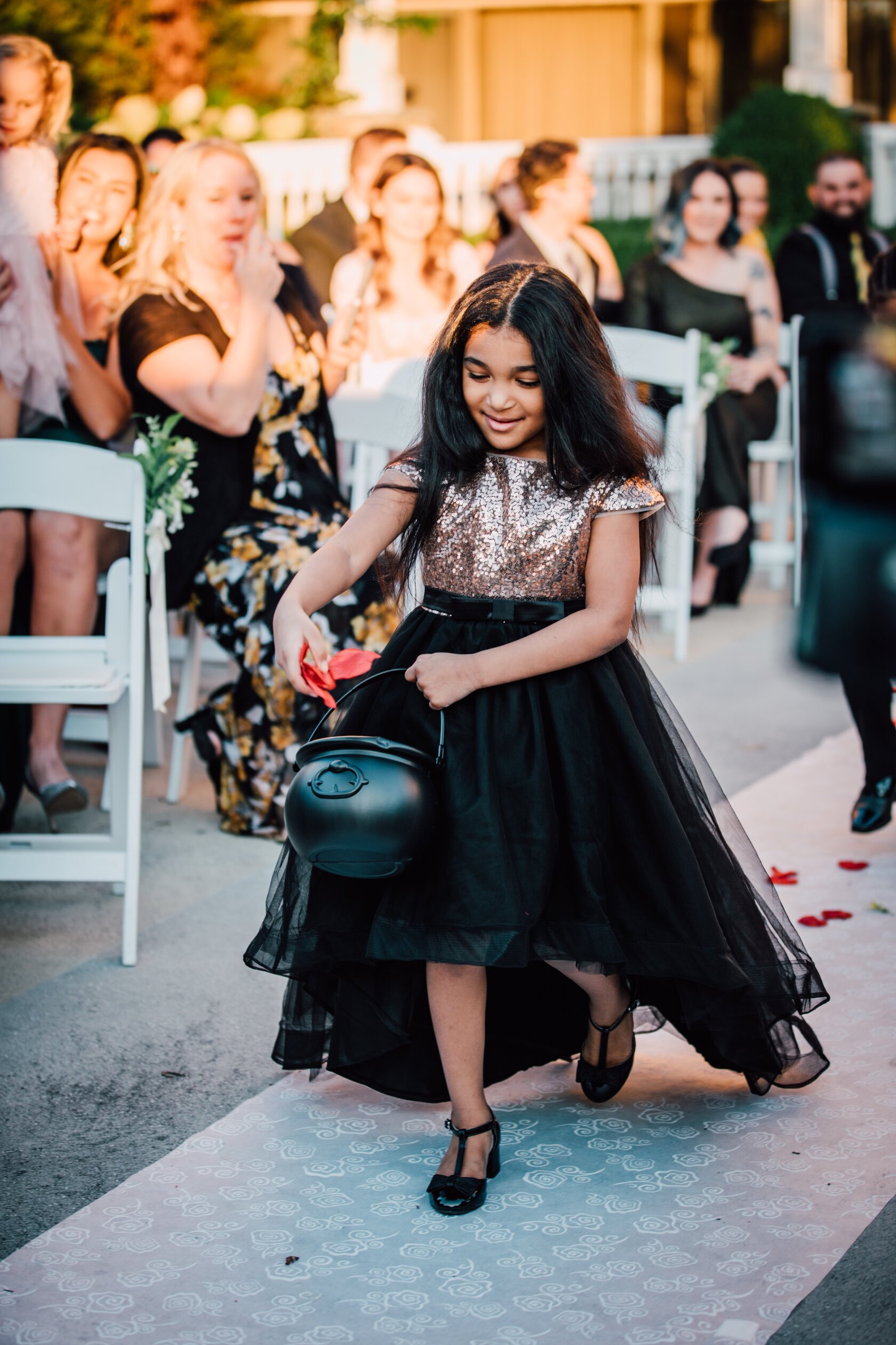  the flower girl throws flower petals from a witch’s pot at a harry potter themed wedding 