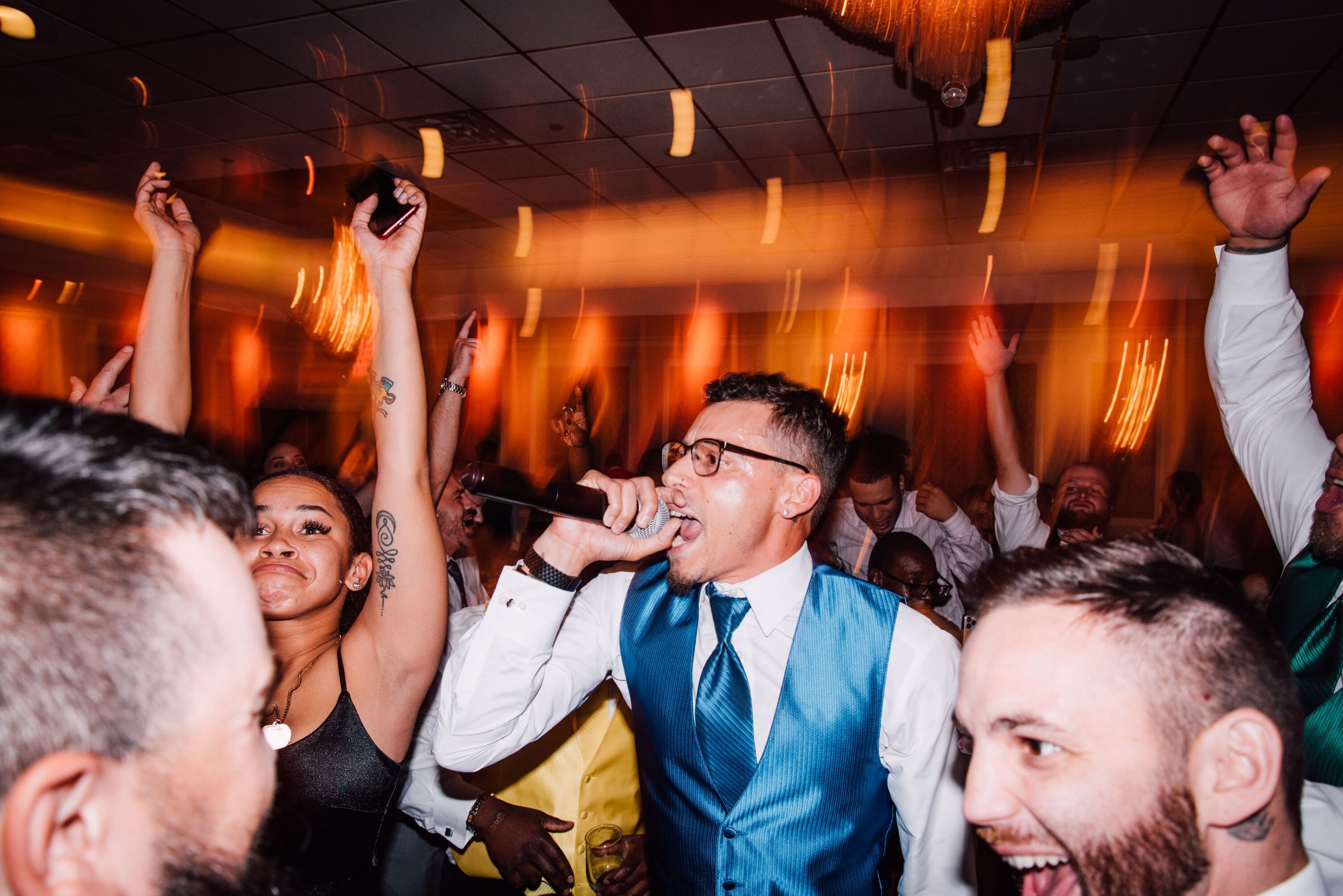  the groom sings into a microphone in the middle of the dance floor at his poughkeepsie grand hotel wedding 