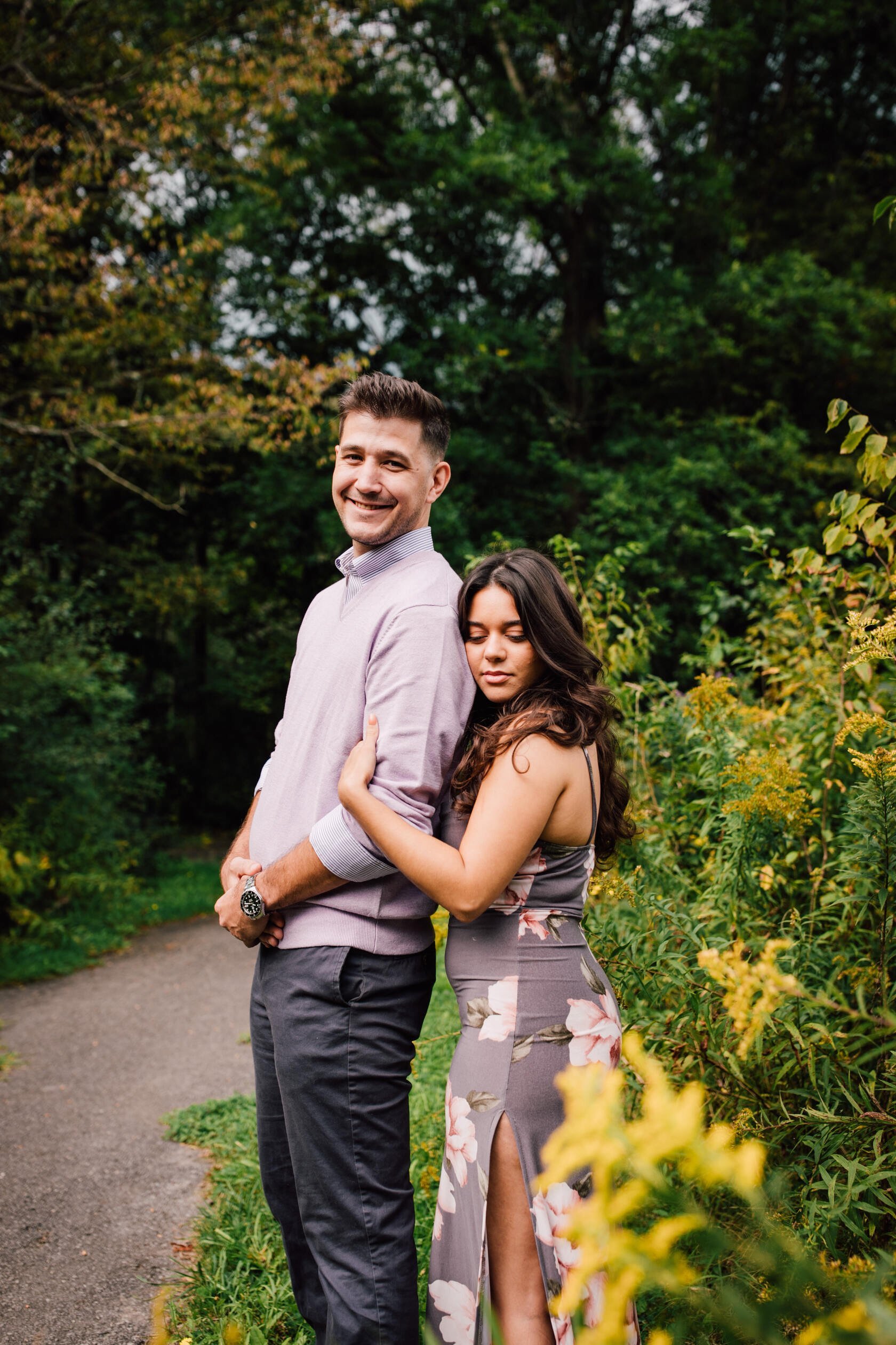  Man smiles with his fiancé holding his arm, waterfall engagement photos 