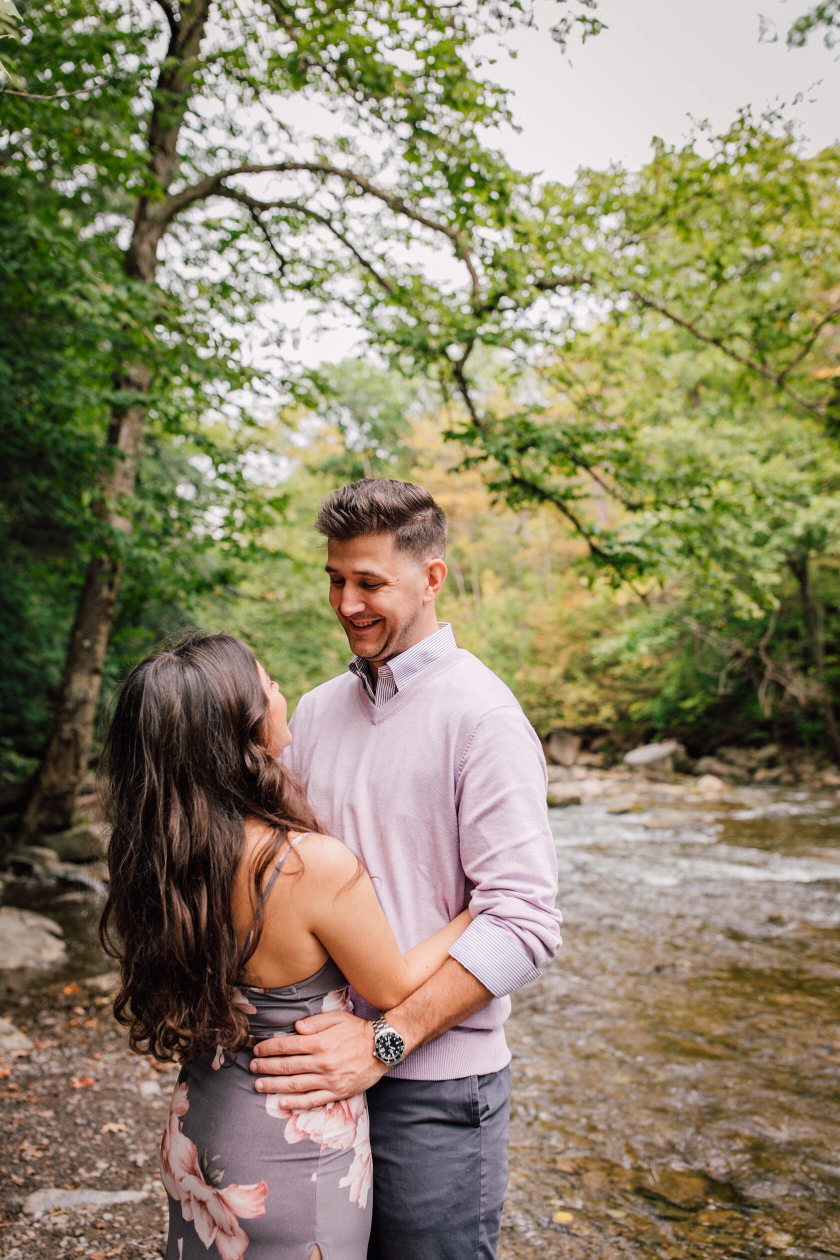  Engaged couple face each other smiling, waterfall engagement photos 