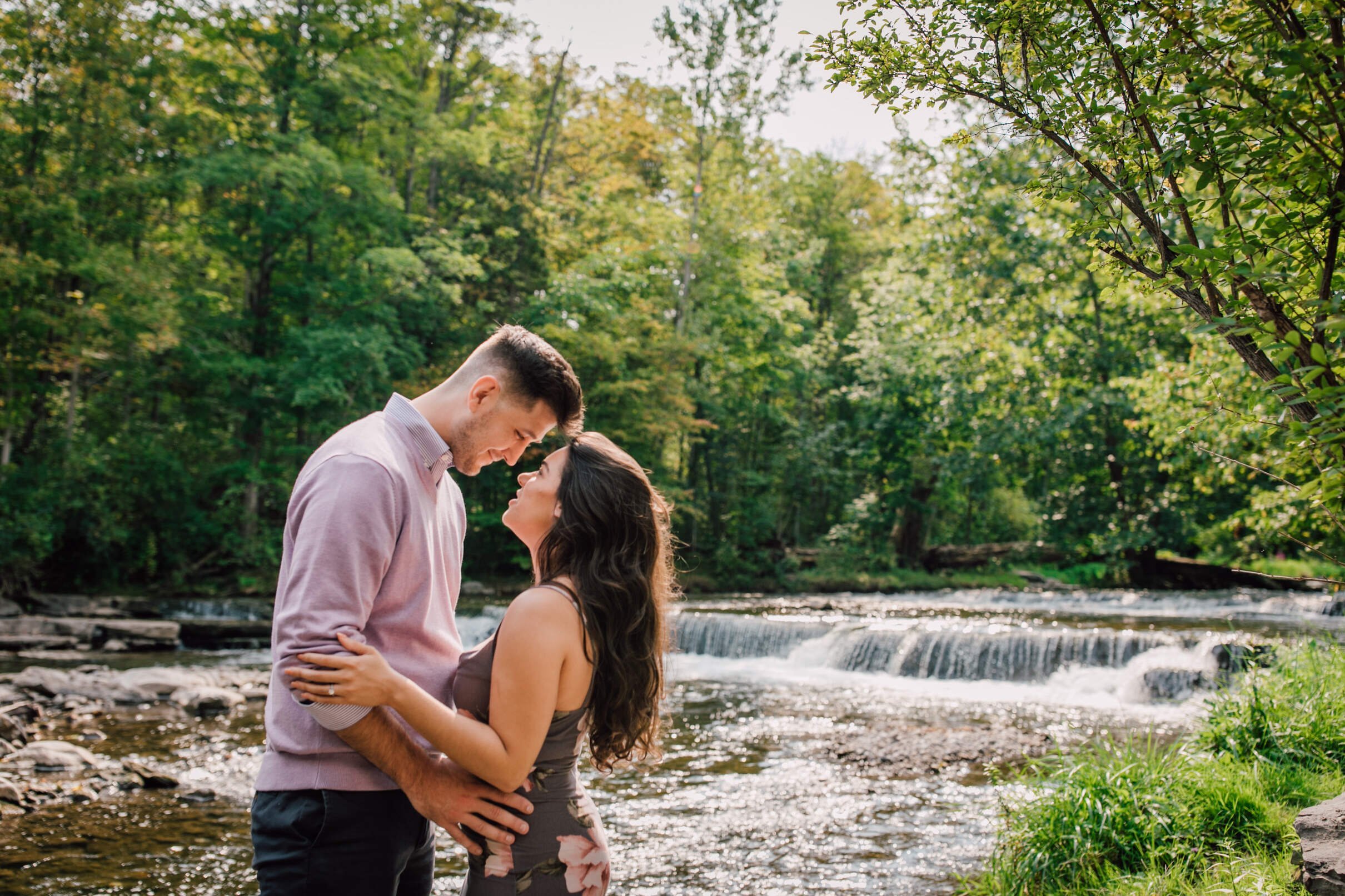  Engaged couple look at each other in front of a waterfall, waterfall engagement photos 
