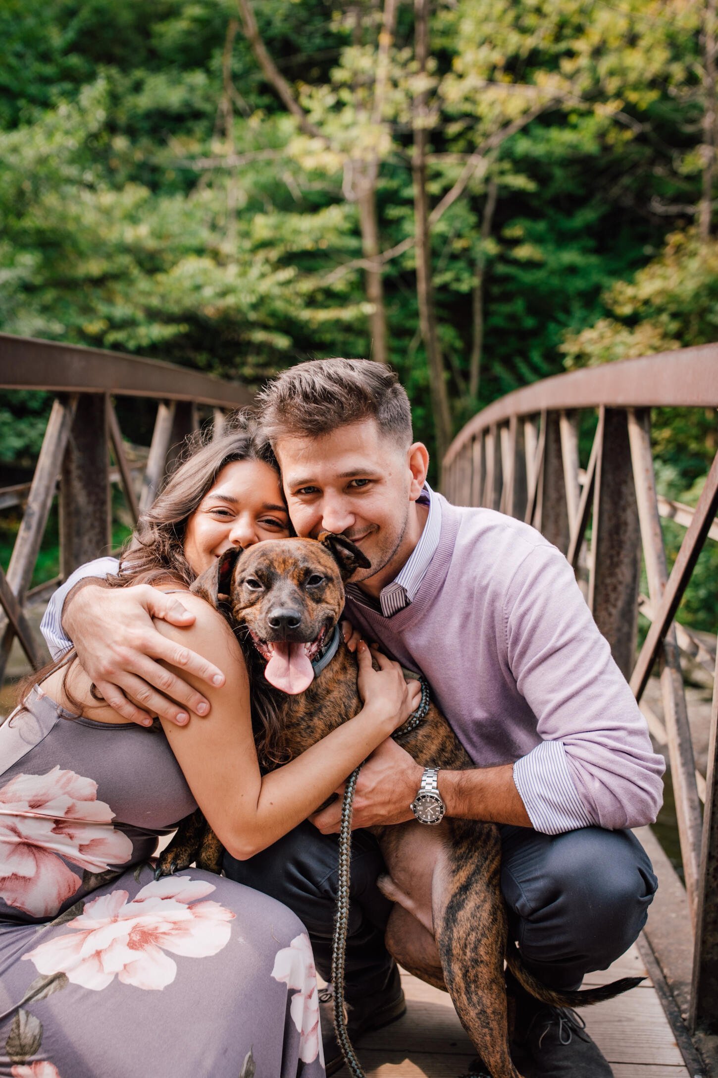  Engaged couple and their dog smile together in a family embrace, dog engagement photos 