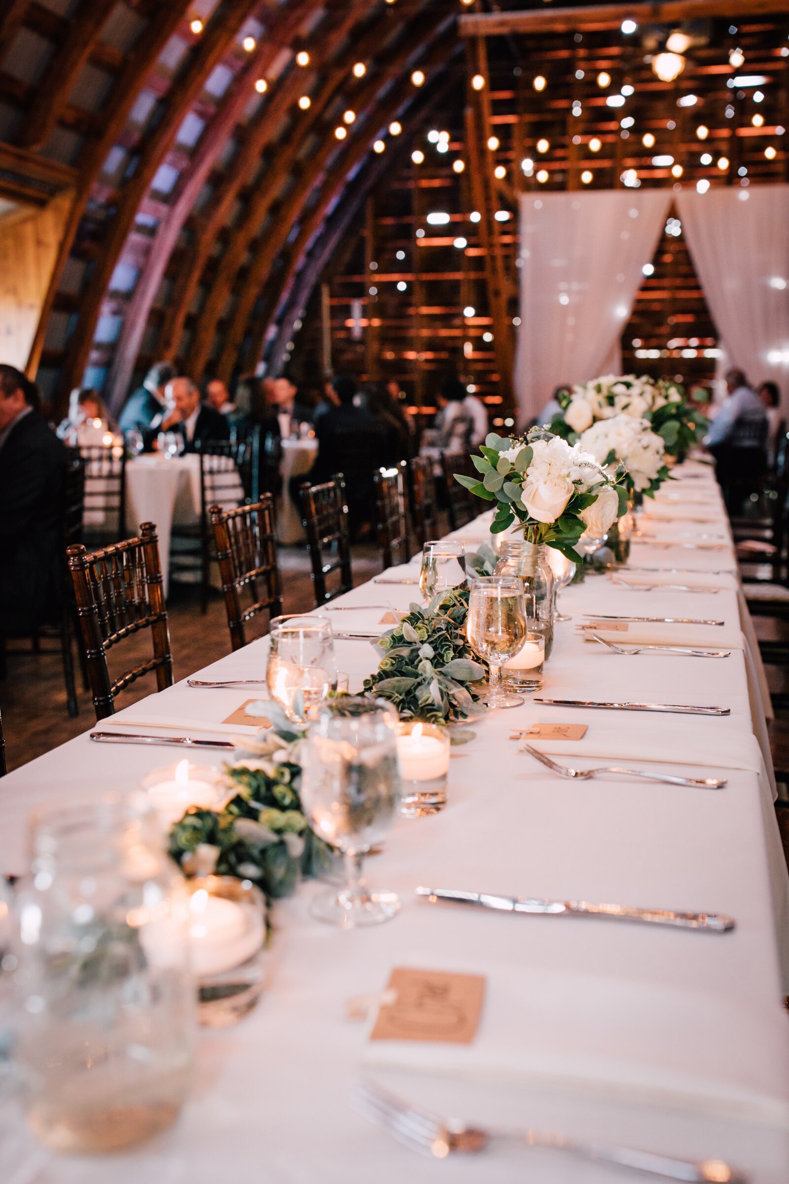  A view of the head table settings for barn wedding decor 