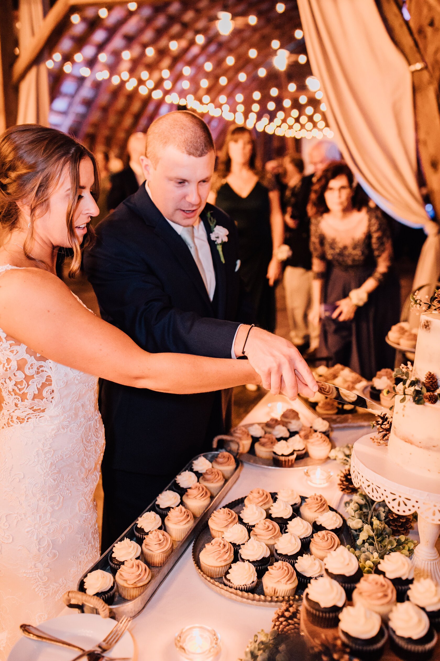  The bride and groom cut their cake at their rustic barn wedding 