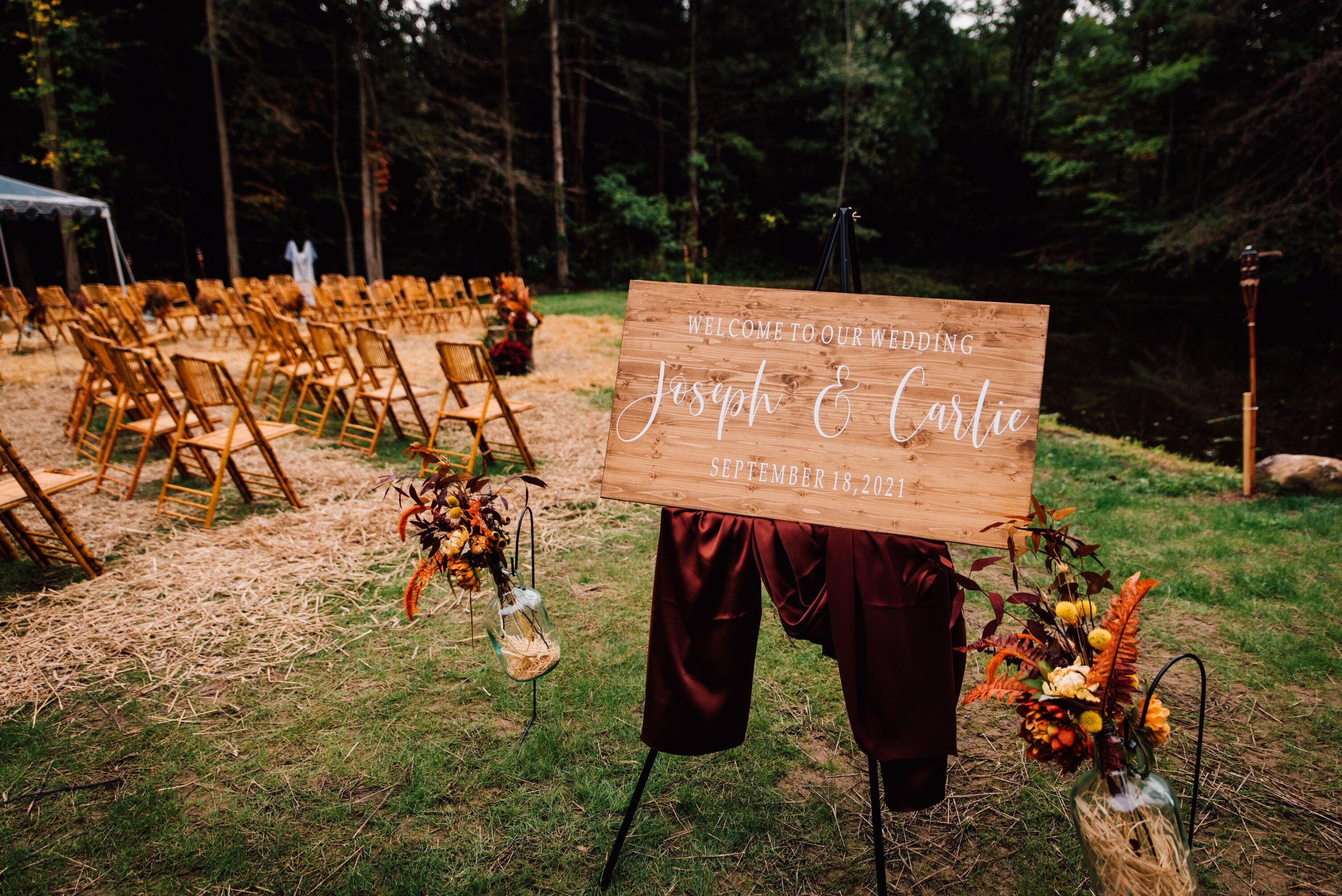  A rustic wedding sign welcomes guests to Joseph and Carlie’s outdoor wedding ceremony 