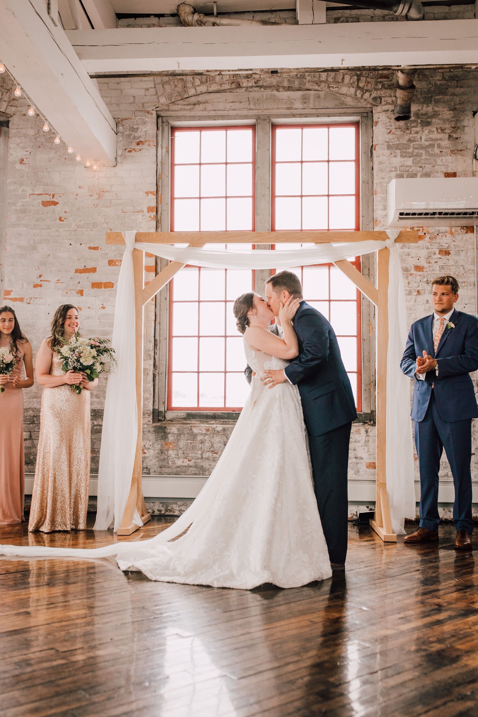  Bride and groom’ first kiss at their industrial wedding venue ceremony 