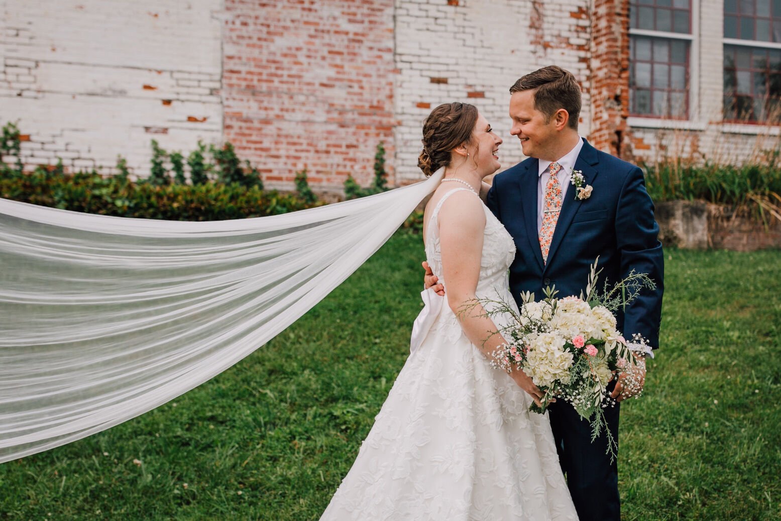  Bride and groom gaze at each other in front of their industrial wedding venue 