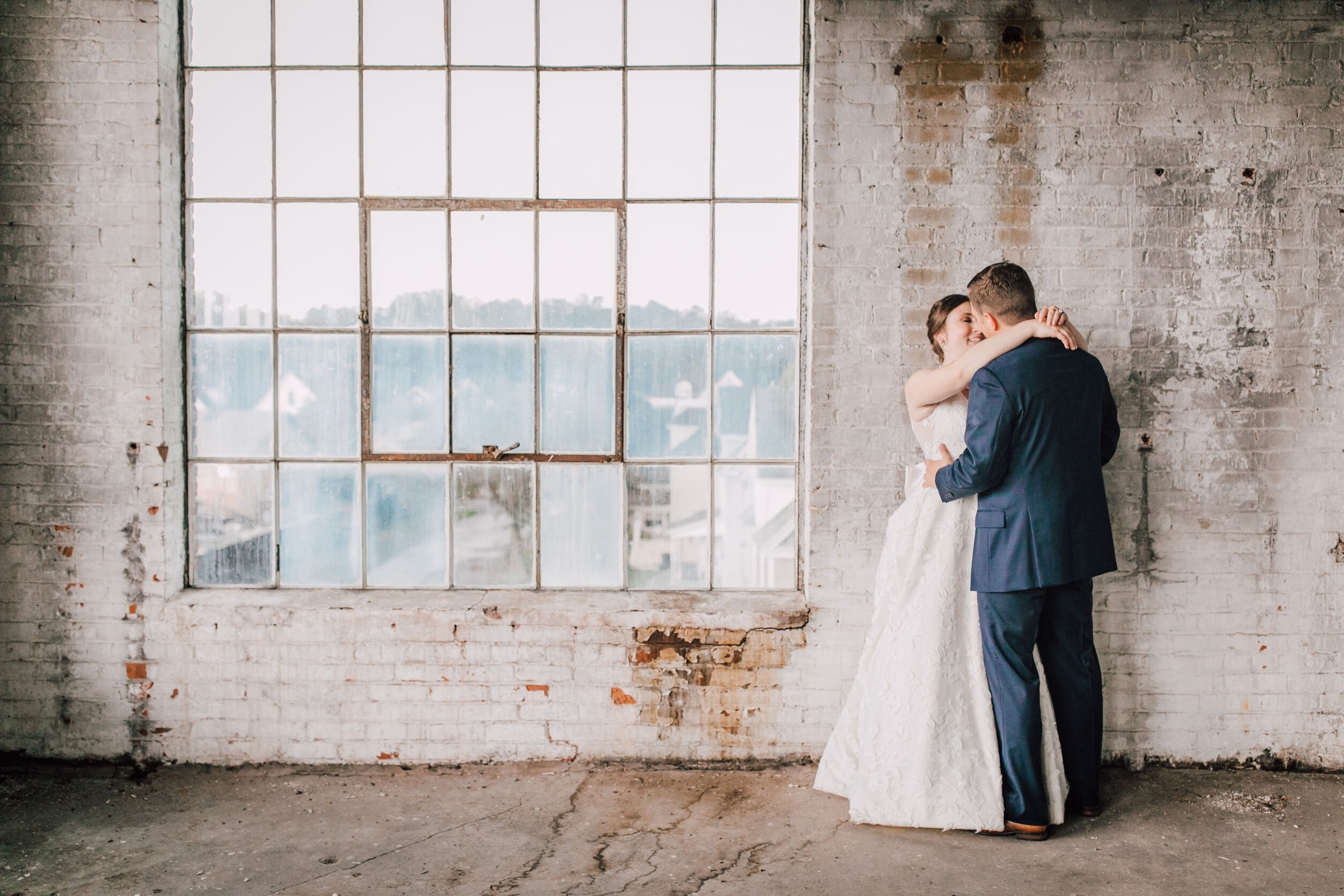  Bride and groom look at each other at their warehouse wedding 