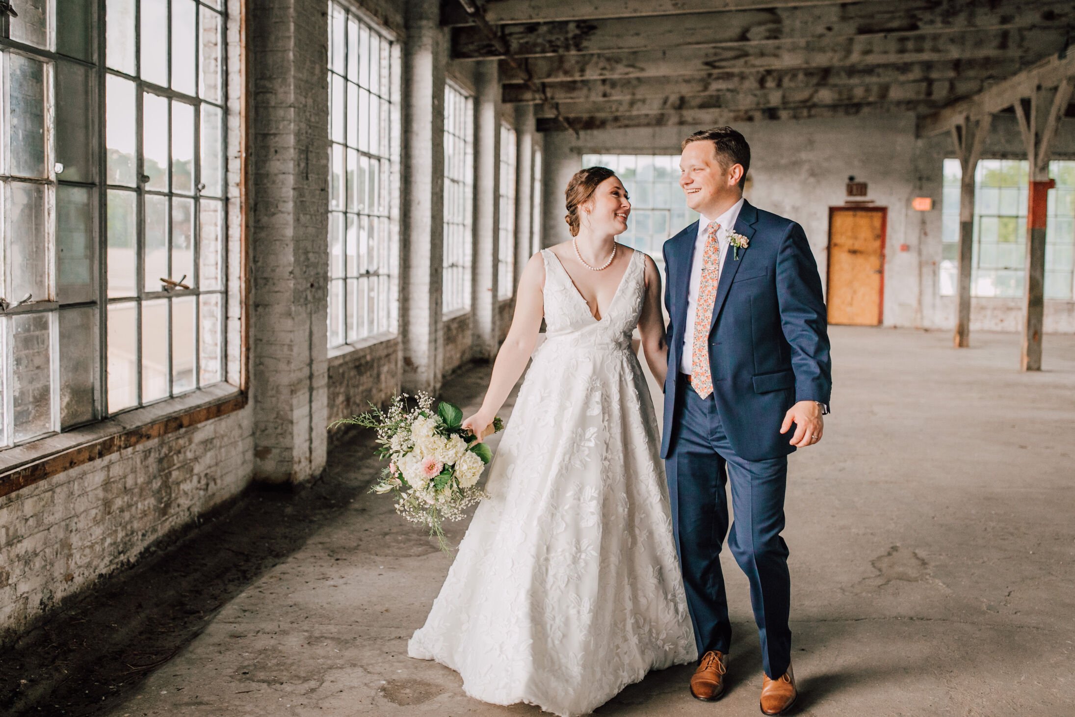  Bride and groom stand in their industrial wedding venue&nbsp; 