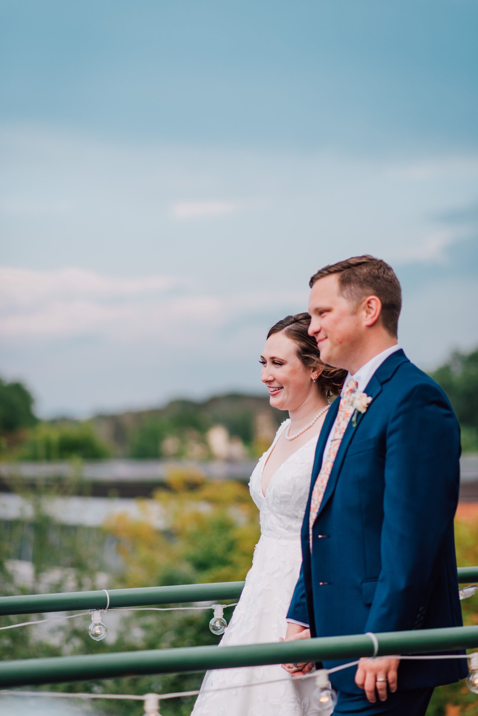  Bride and groom walk on a walkway at their cracker factory wedding 