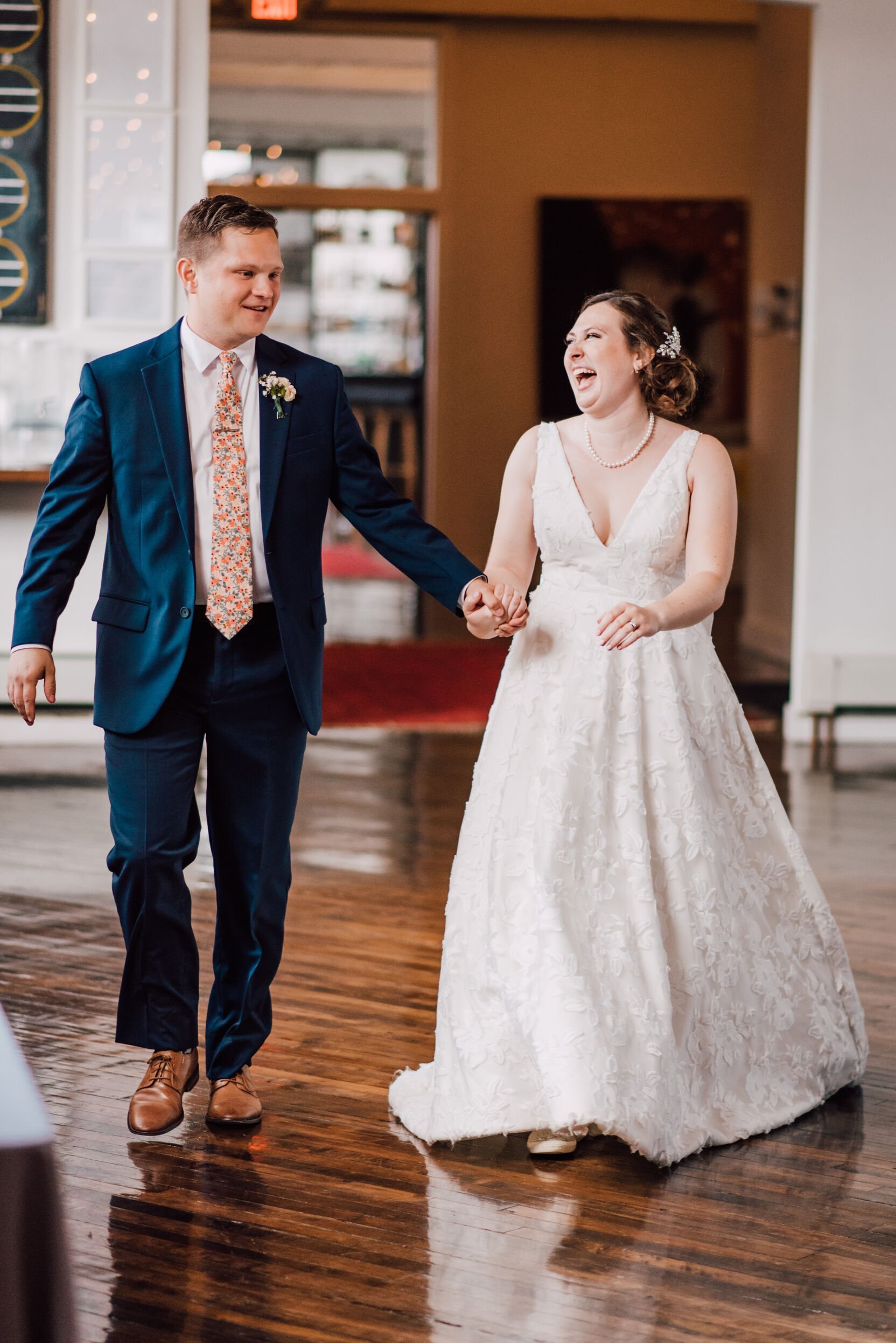  Bride and groom walk into their vow renewal reception at the cracker factory 