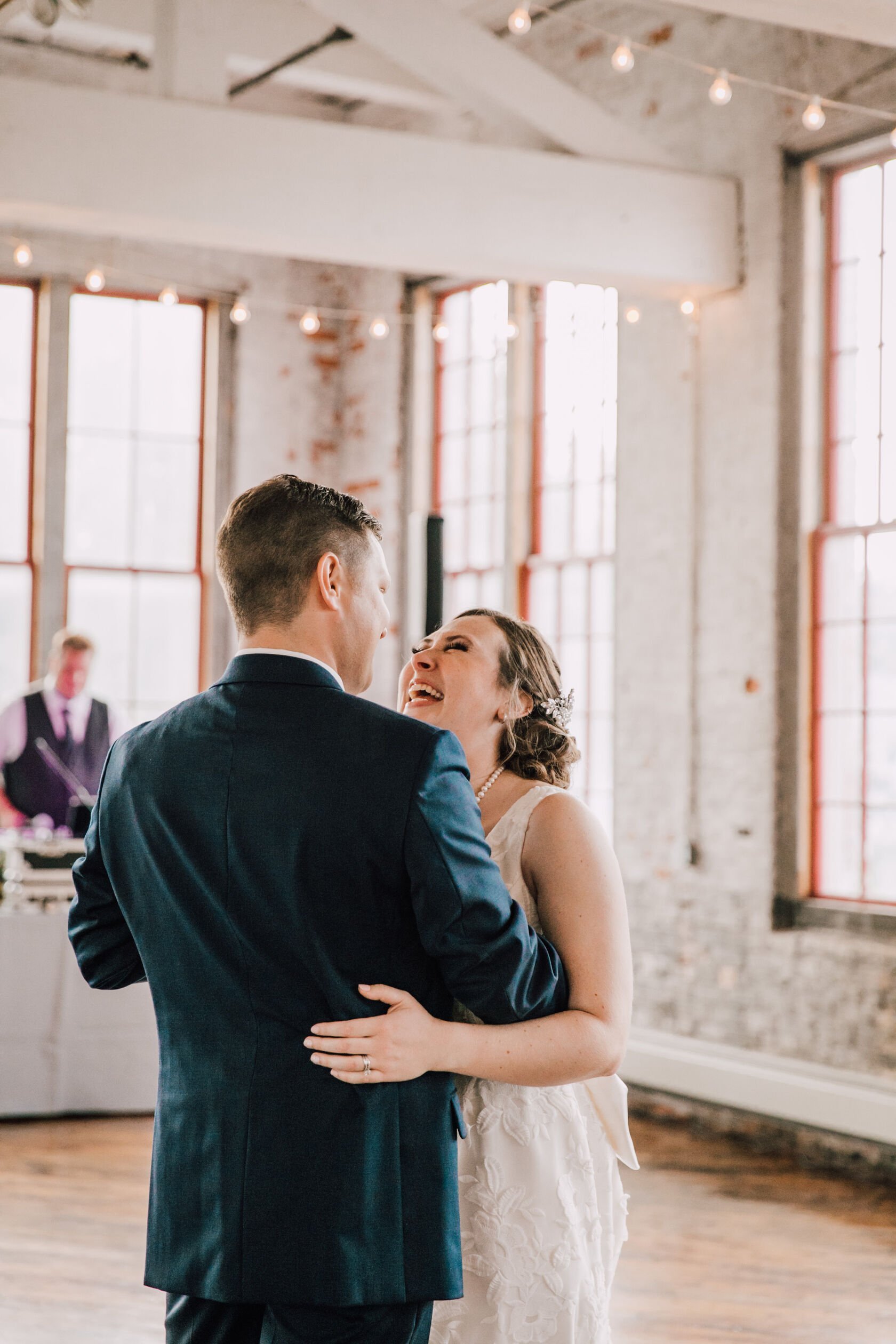  Bride and groom laugh during their first dance at their cracker factory reception 