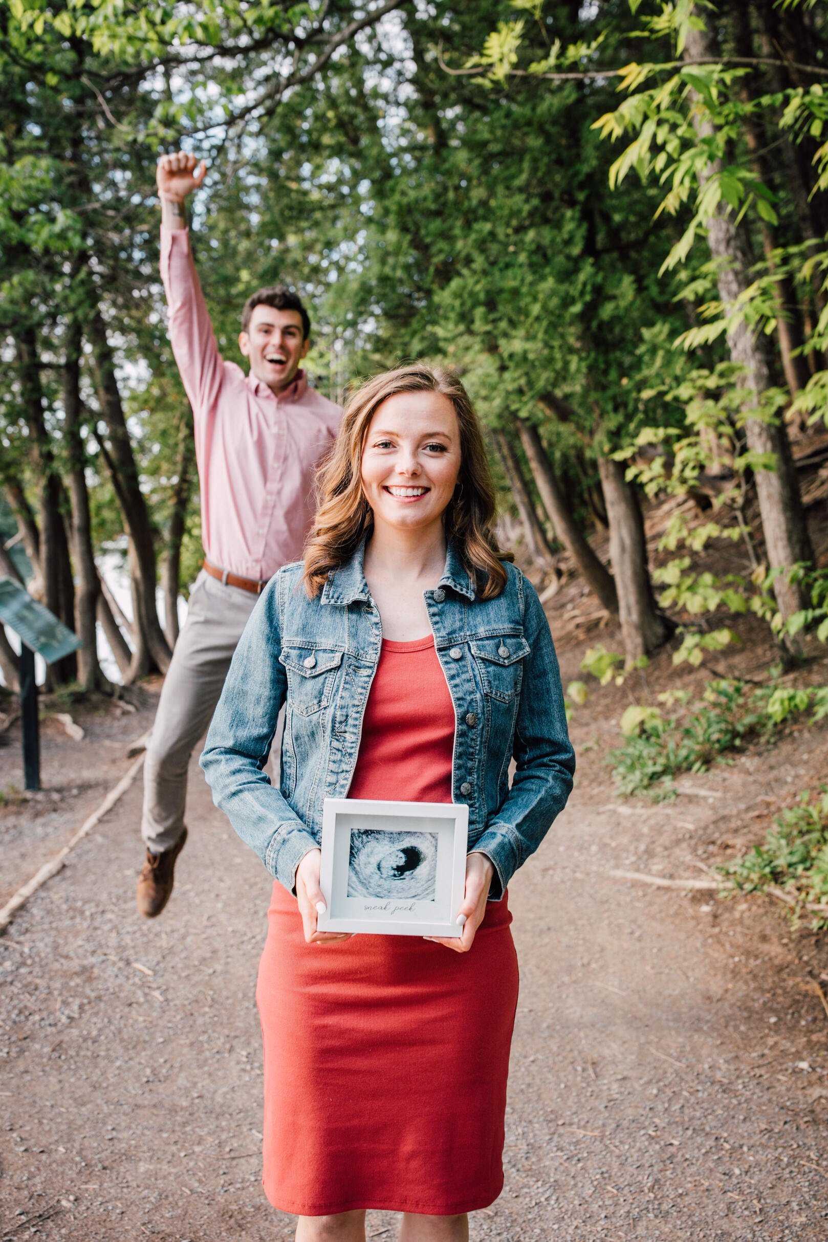  Pregnancy announcement ideas dad to be jumps out of excitement in the background while mom to be holds ultrasound photo 