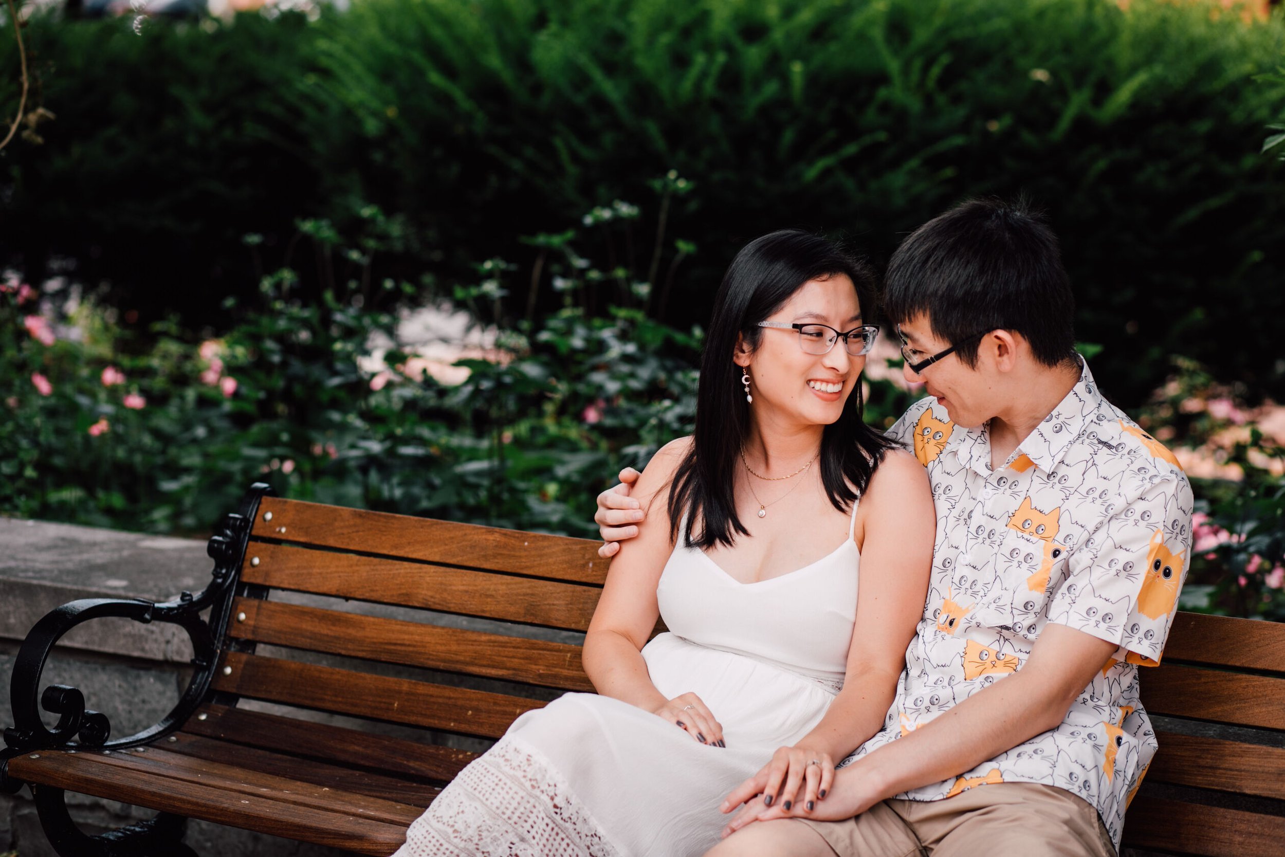  An engaged couple sit next to each other while smiling at each other on a park bench, Franklin square park, Syracuse&nbsp; 