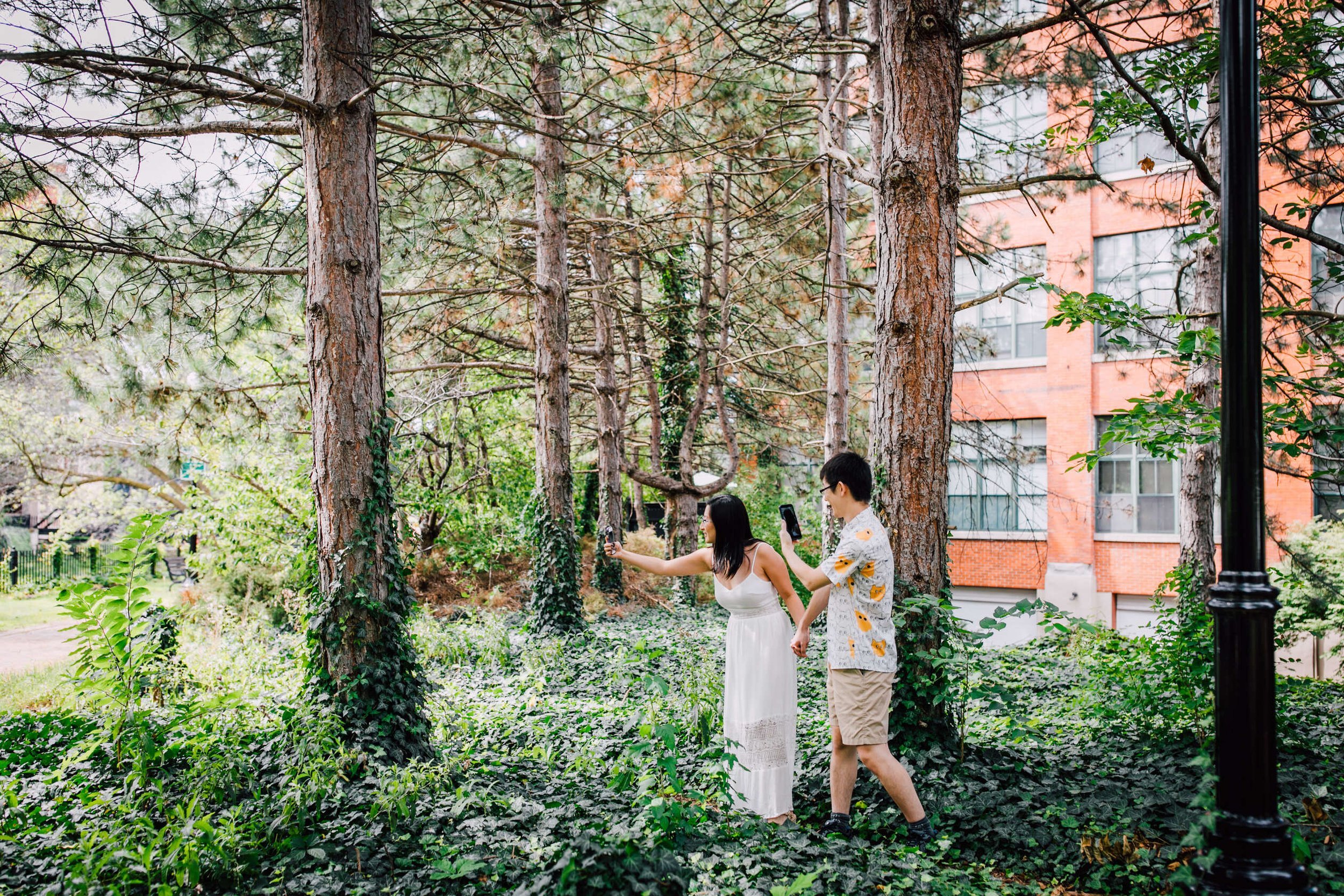  An engaged couple play Pokemon go in the woods, nerdy engagement photos 