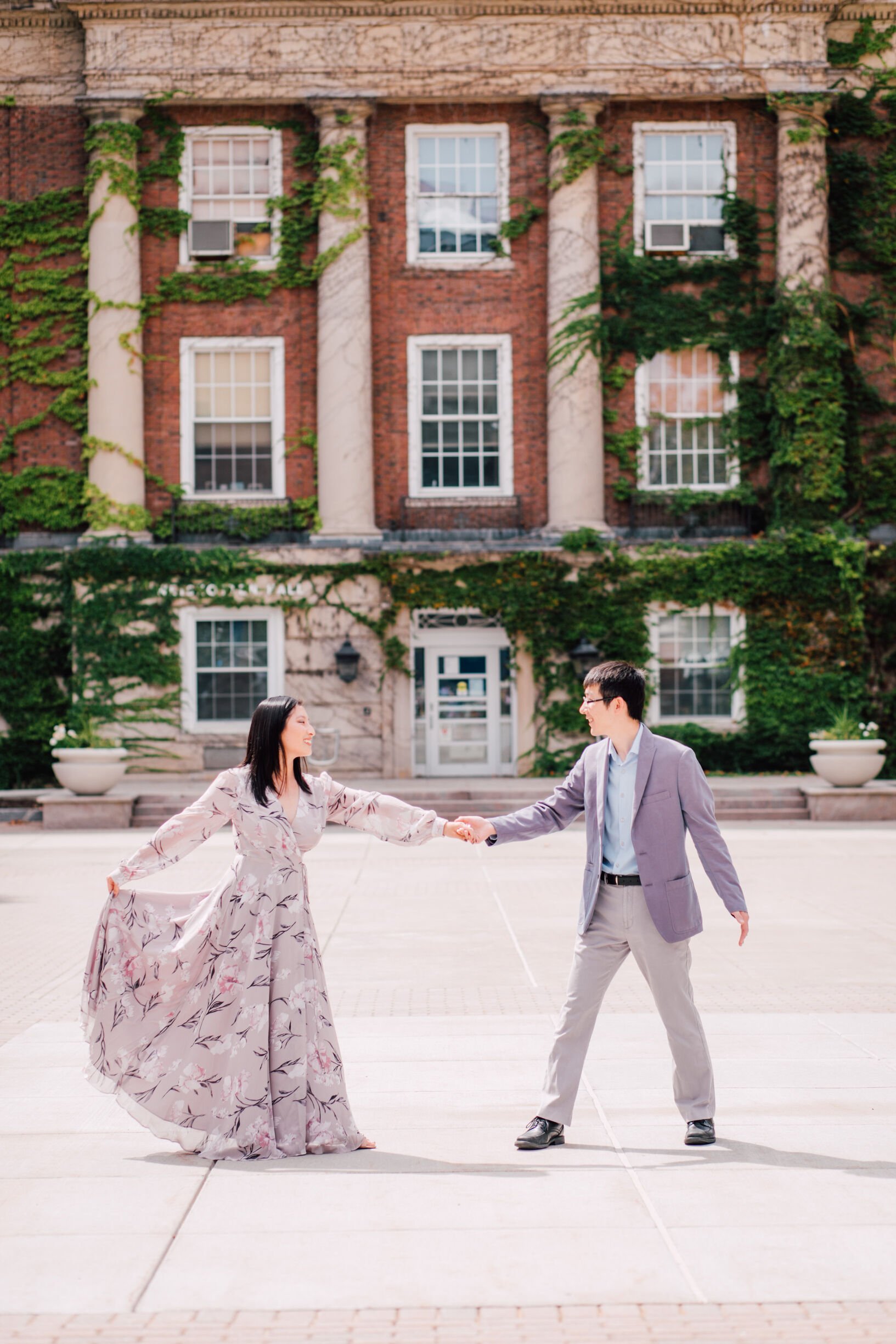  Engaged couple dance in front of the college where they met, SUNY upstate 