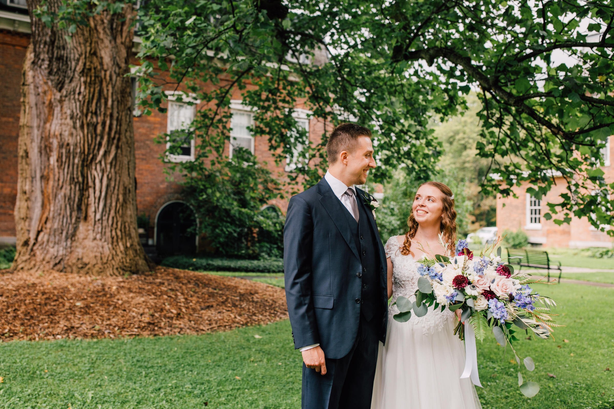  bride and groom look at each other excitedly during their first look before their outdoor wedding ceremony 