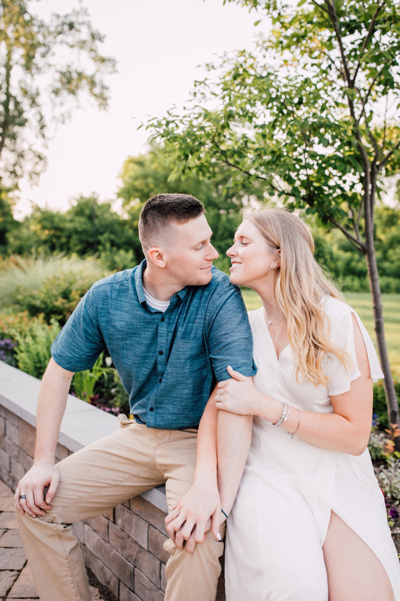  Engaged couple smile at each other during farm engagement photos 