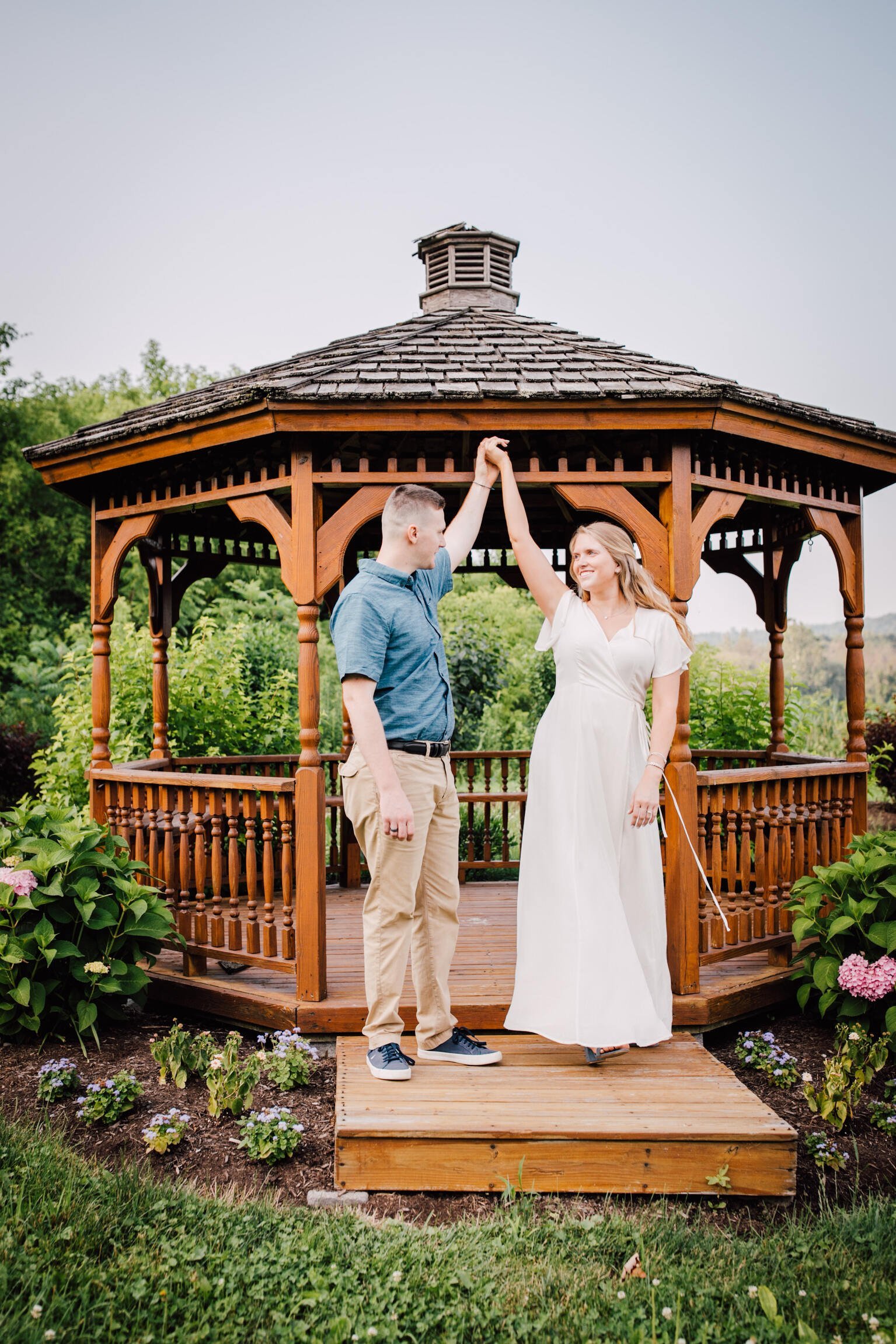  Engaged couple dance together in front of a gazebo at the orchards at rocking horse farm 