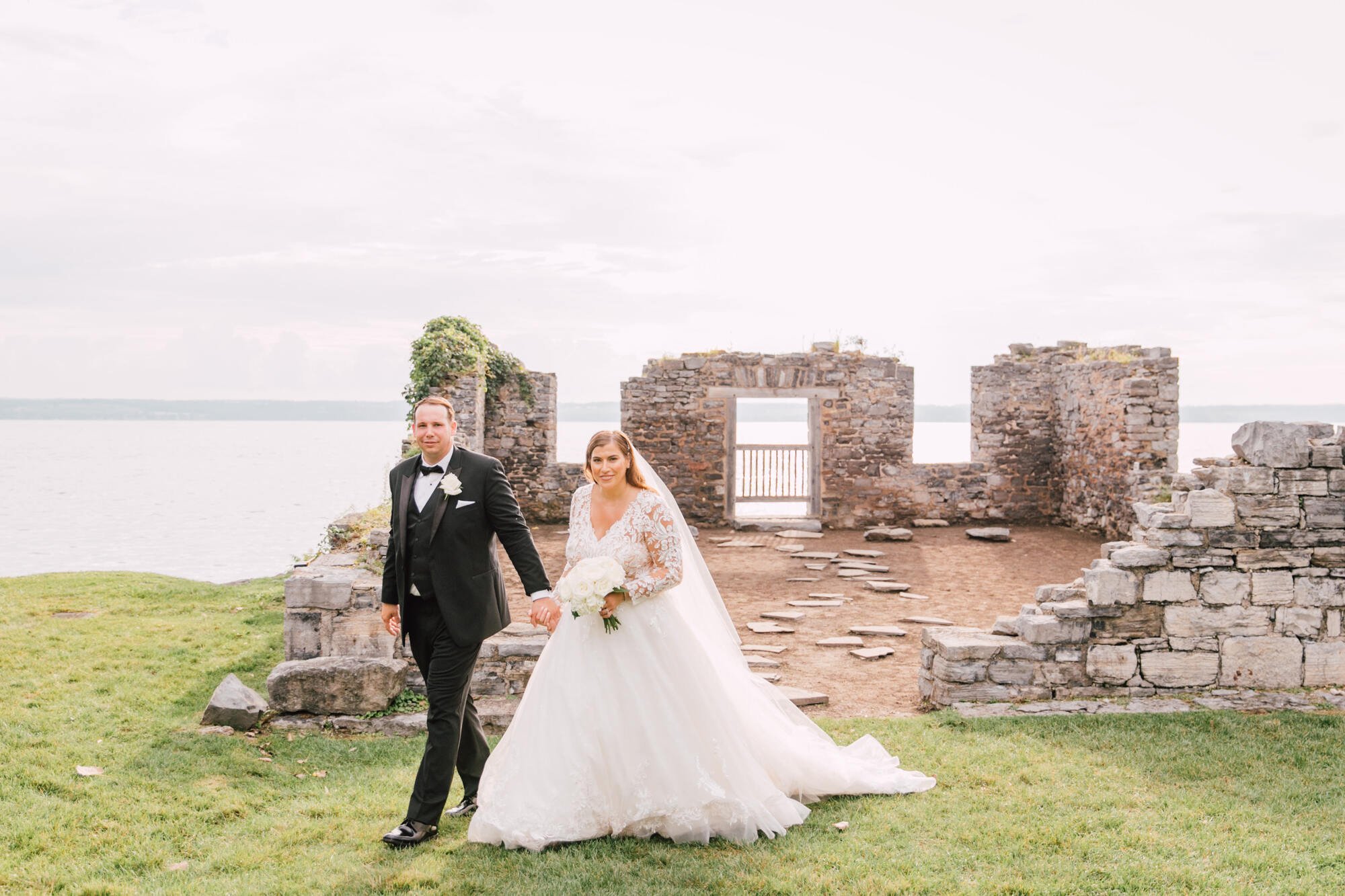  Bride and groom walk away from the lake at their cayuga lake wedding&nbsp; 
