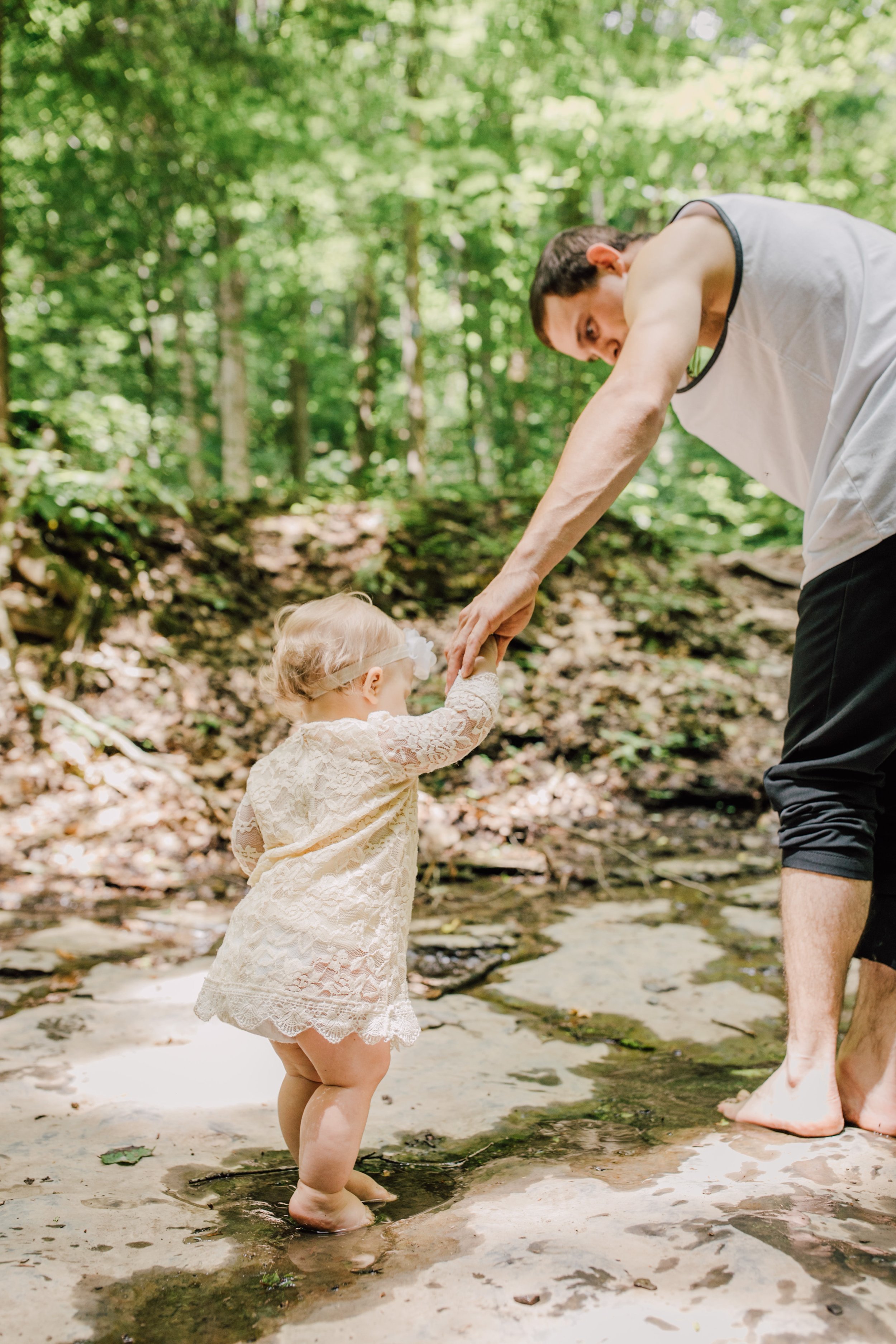  Dad helps his baby girl walk on a rock during their adventure photoshoot 