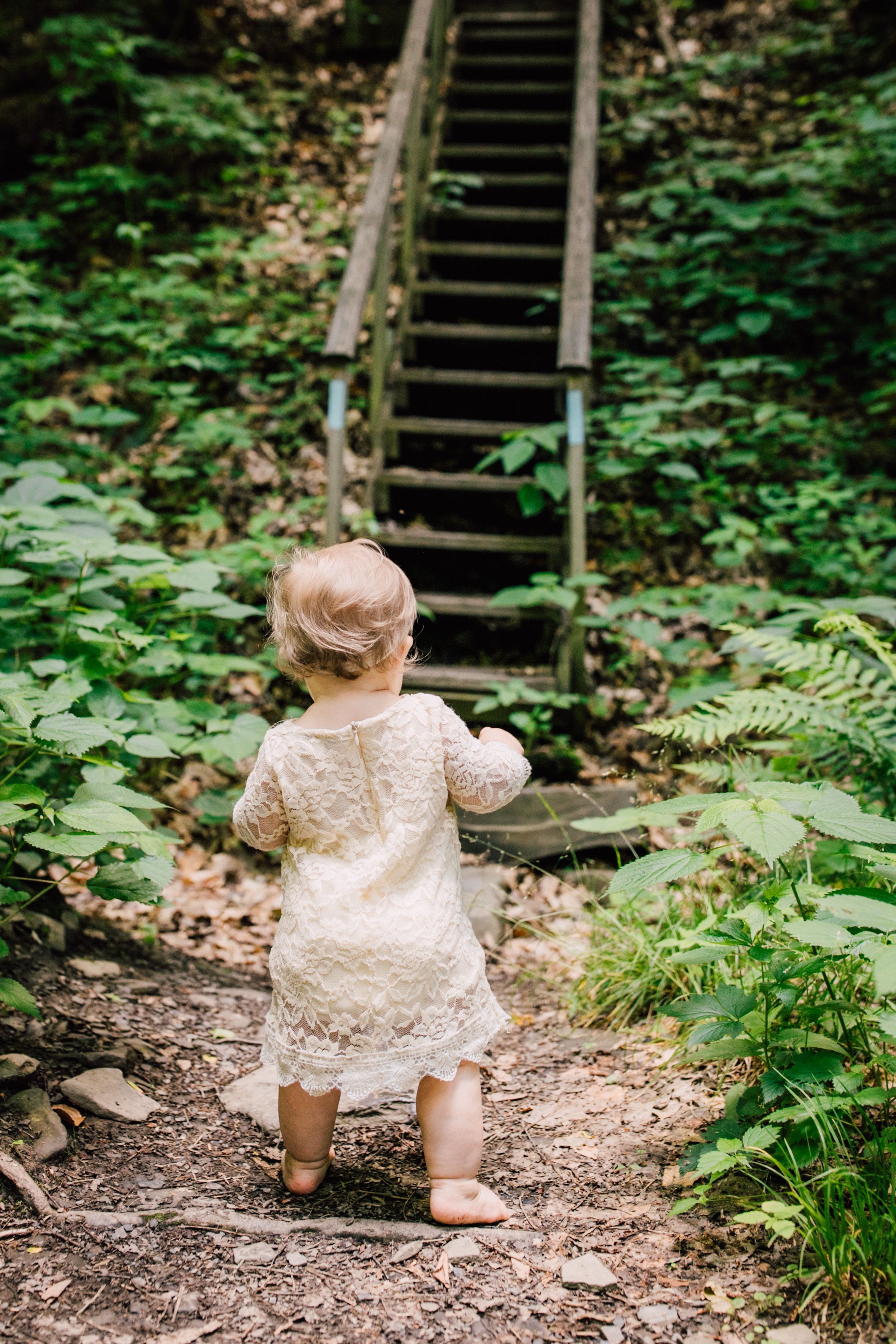  Toddler girl walks in the woods during an adventure photoshoot 
