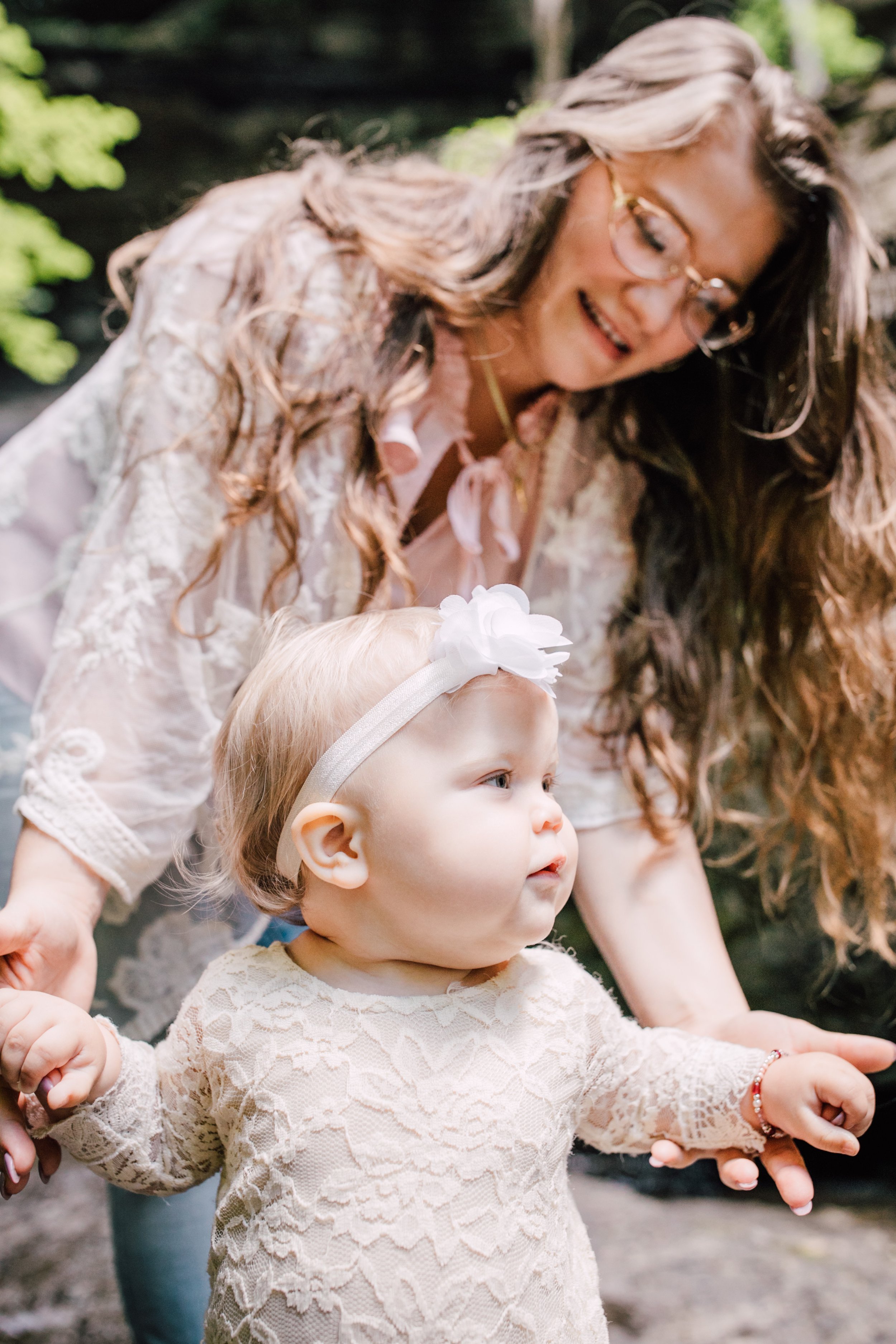  Mom helps her little girl walk during a family adventure 