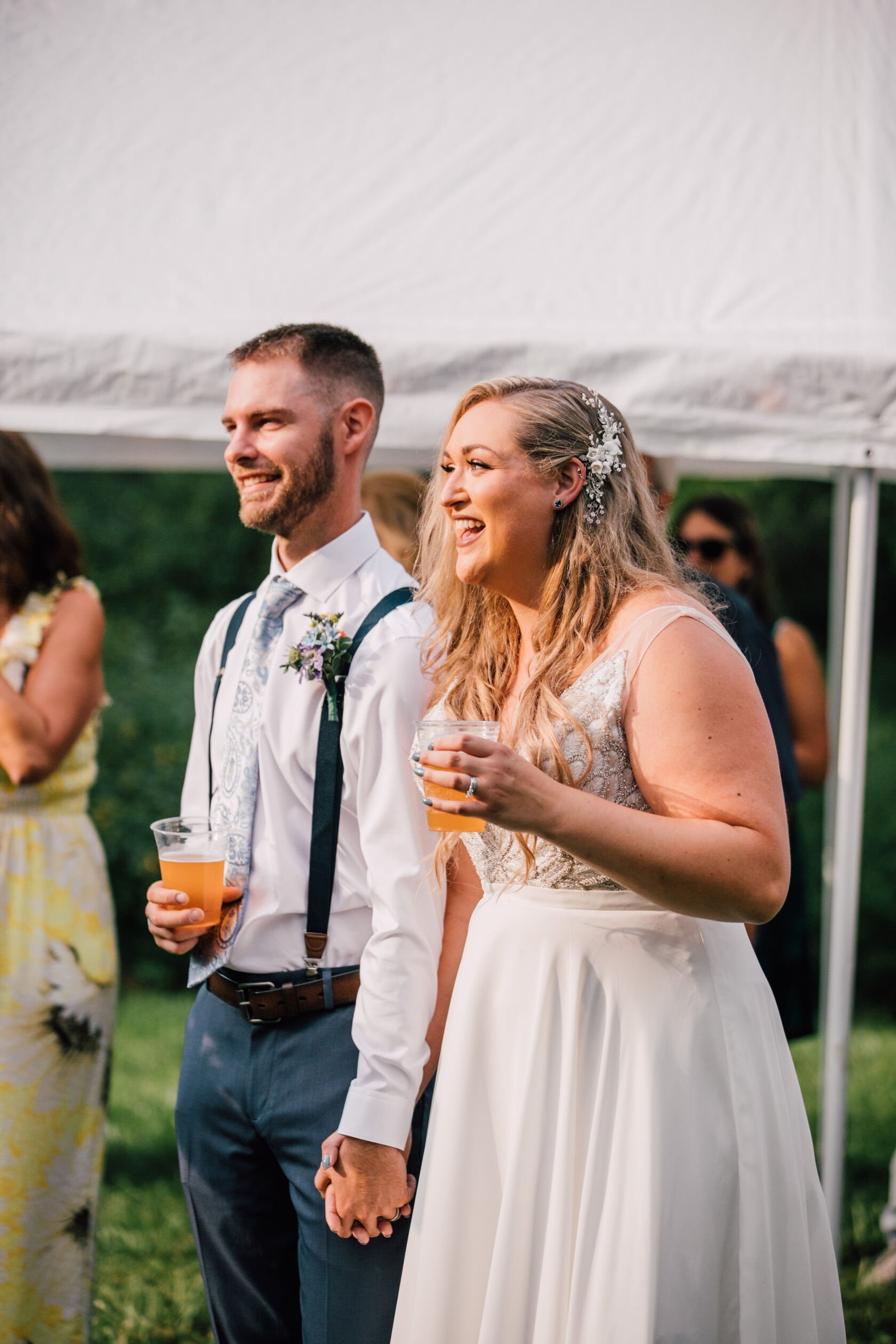  Bride and groom smile during toasts at their backyard wedding&nbsp; 