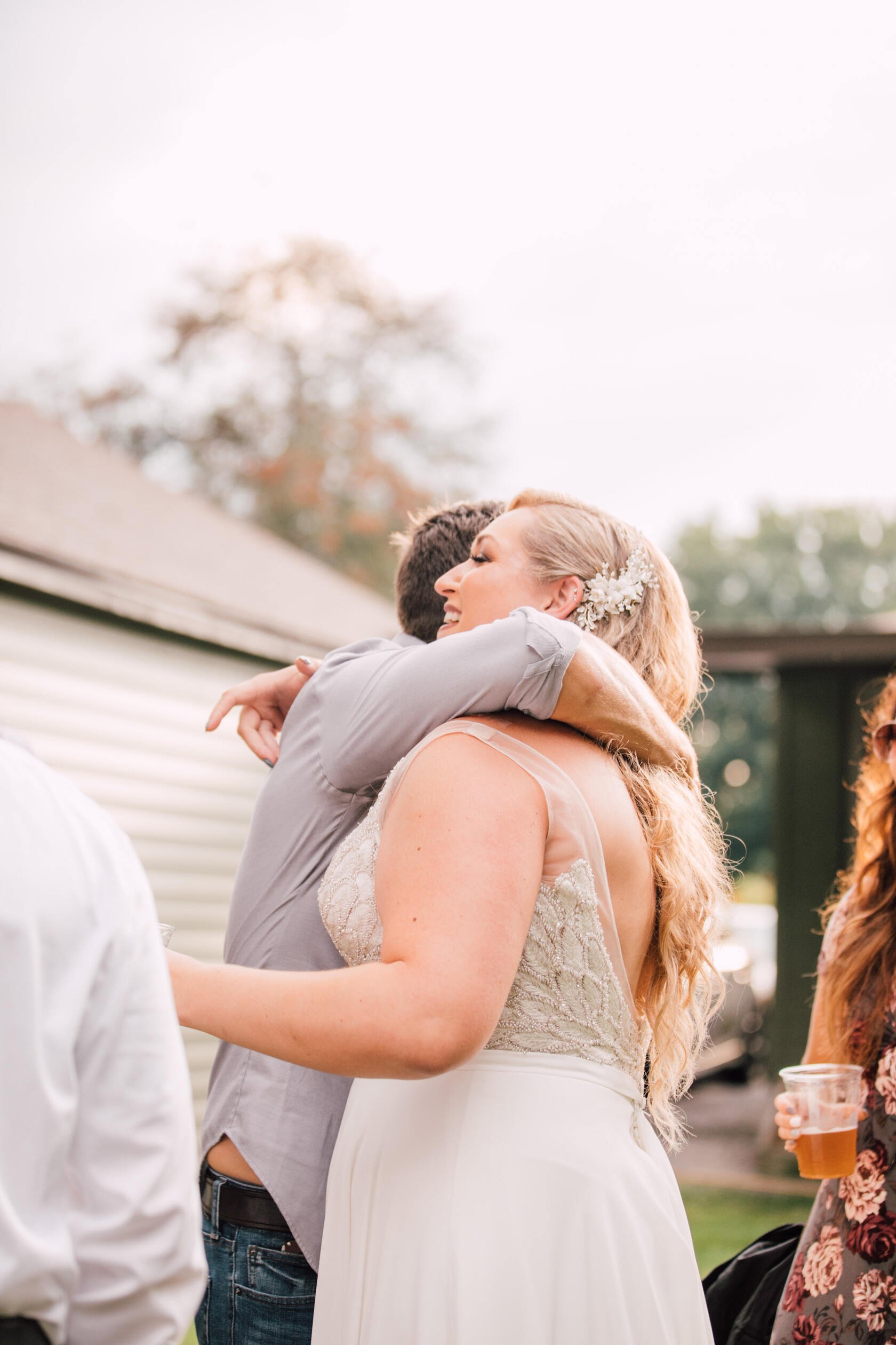  Bride hugs a guest goodbye at her backyard wedding 