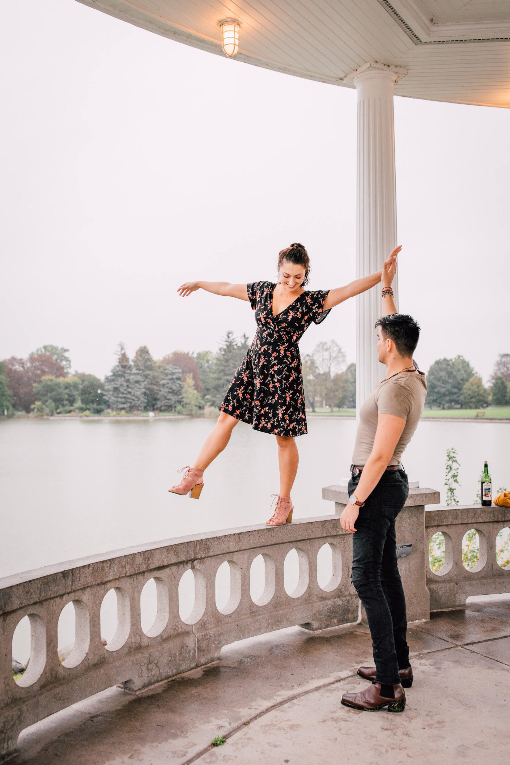  pablo supports jessica as she walks on a railing of a gazebo during their romantic photoshoot  