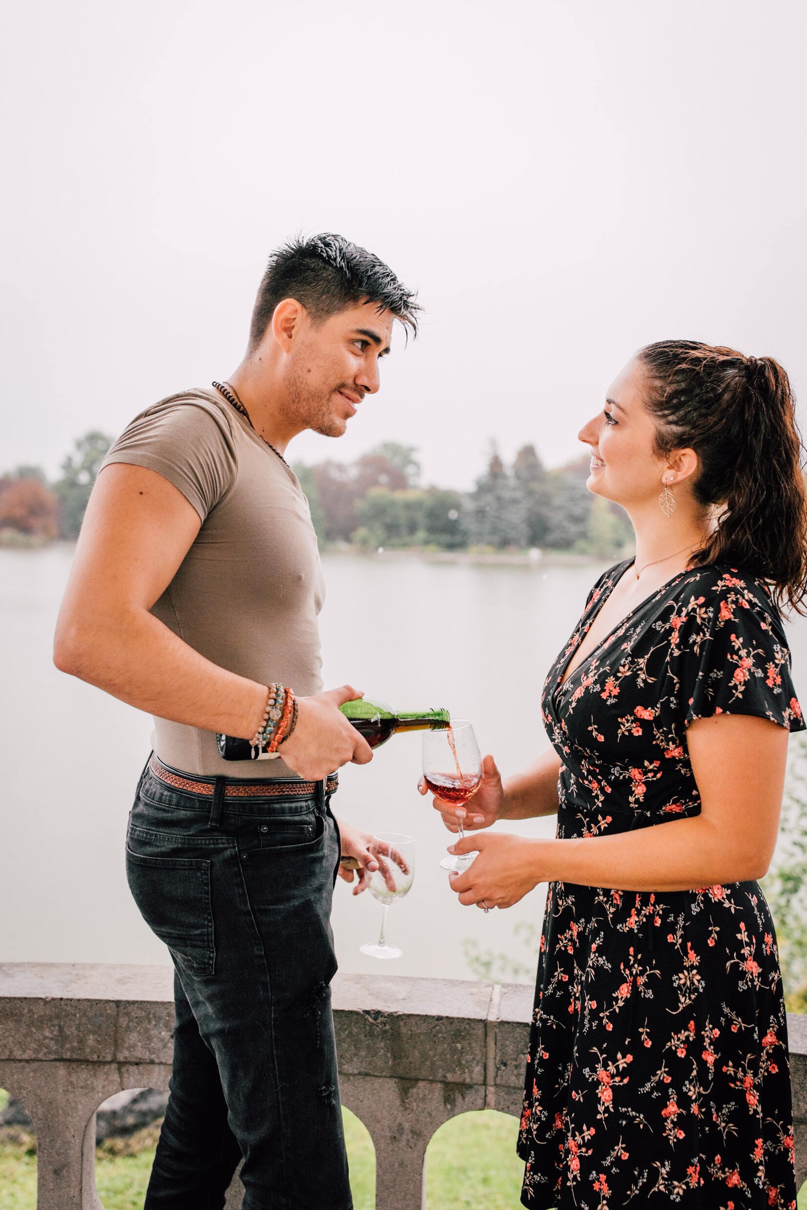  pablo pours wine into jessica’s glass as they look intently at one another during their romantic photoshoot 