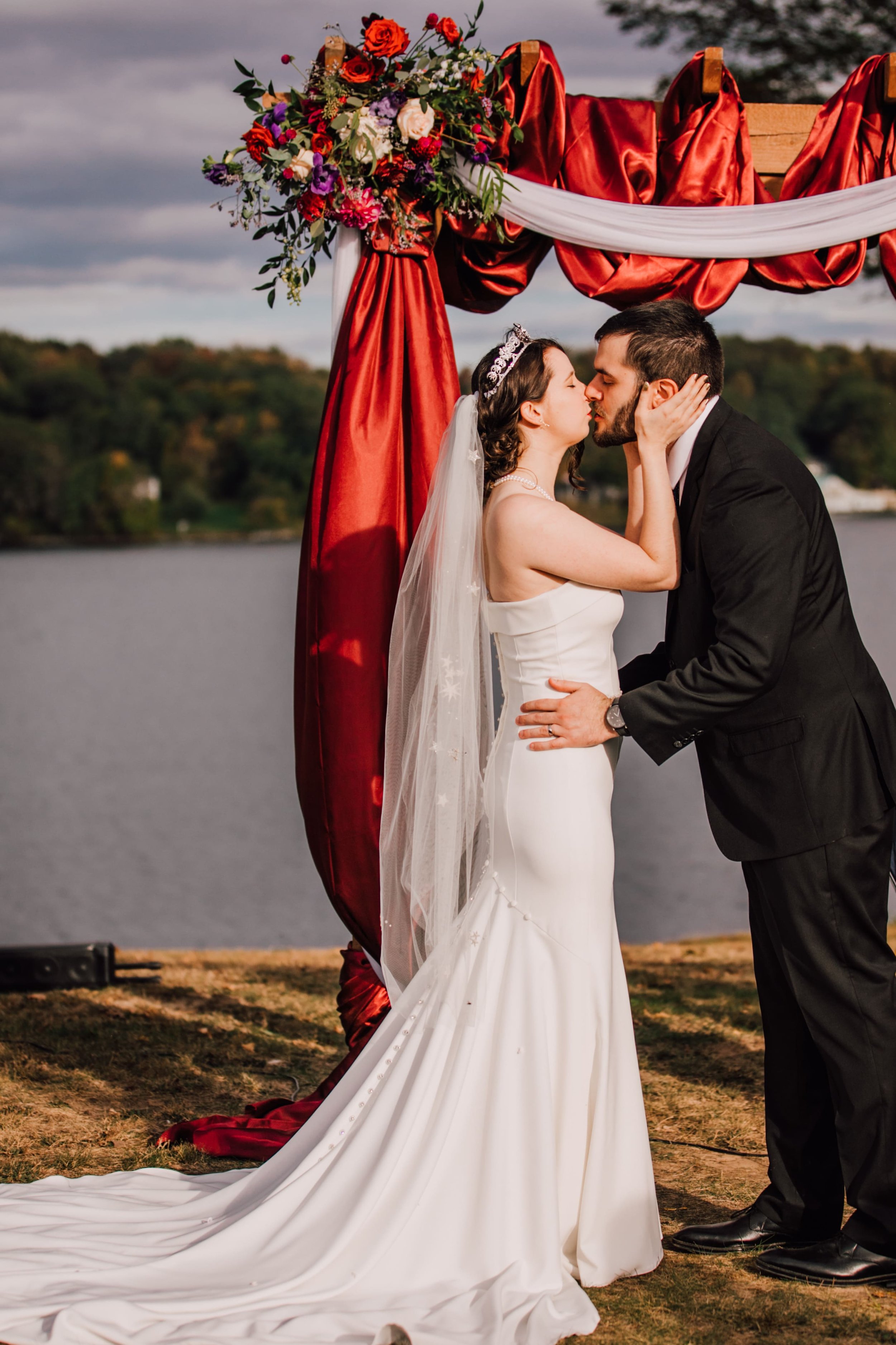  the bride and groom share their first kiss during their lake ontario wedding ceremony 