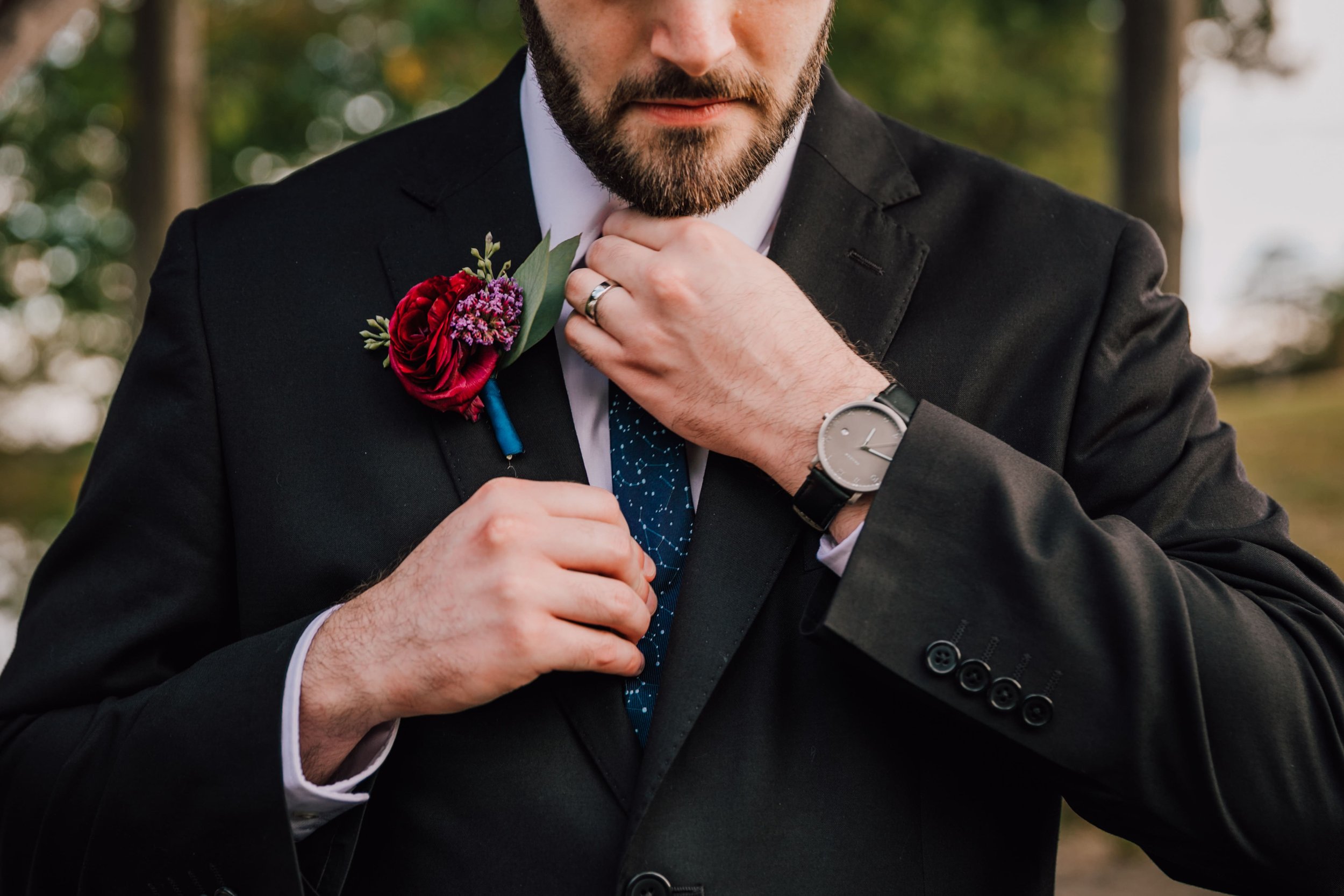 the groom straightens his tie during his october celestial wedding 