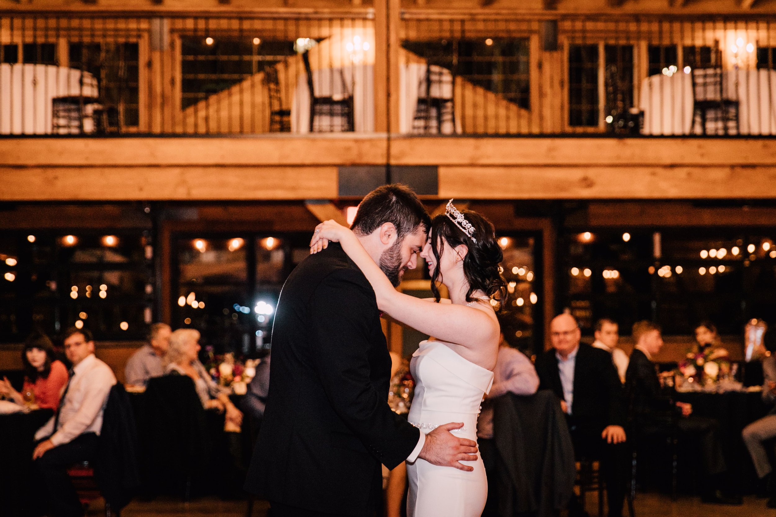  the bride and groom press their foreheads together as they share their first dance at their starry night wedding 