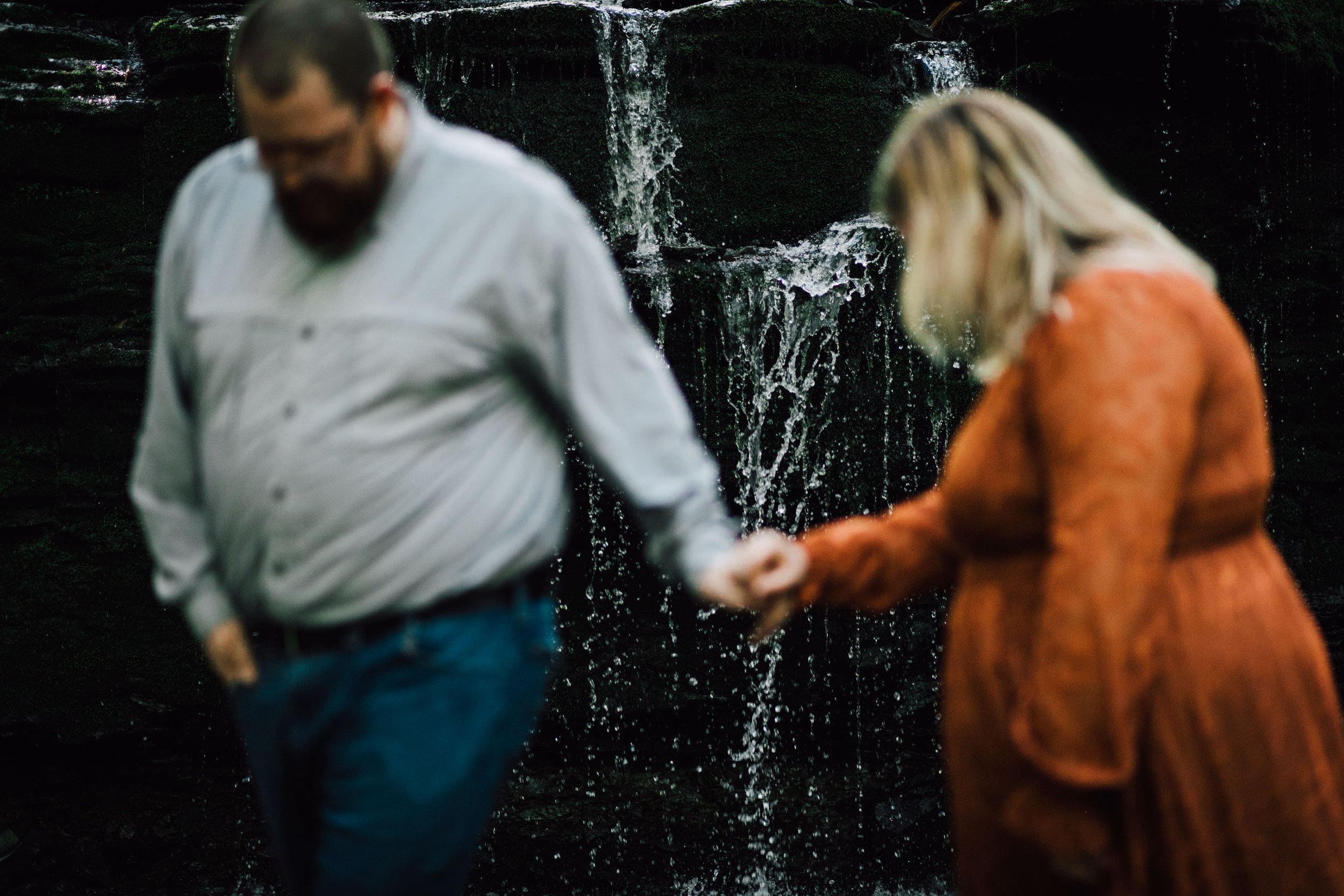  central ny photographer focuses on the waterfall at labrador hollow as an engaged couple stands in the foreground 