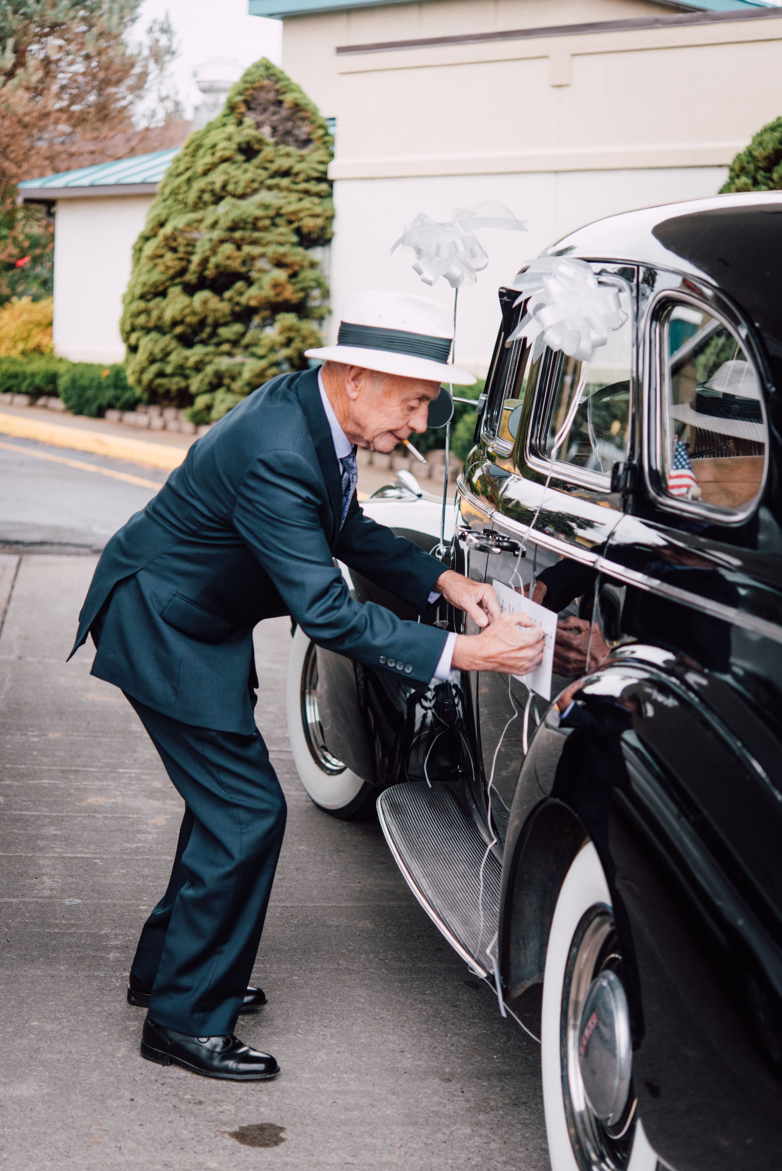  the bride’s grandfather puts finishing touches on his car that the bride is taking to the ceremony in Endwell, NY 