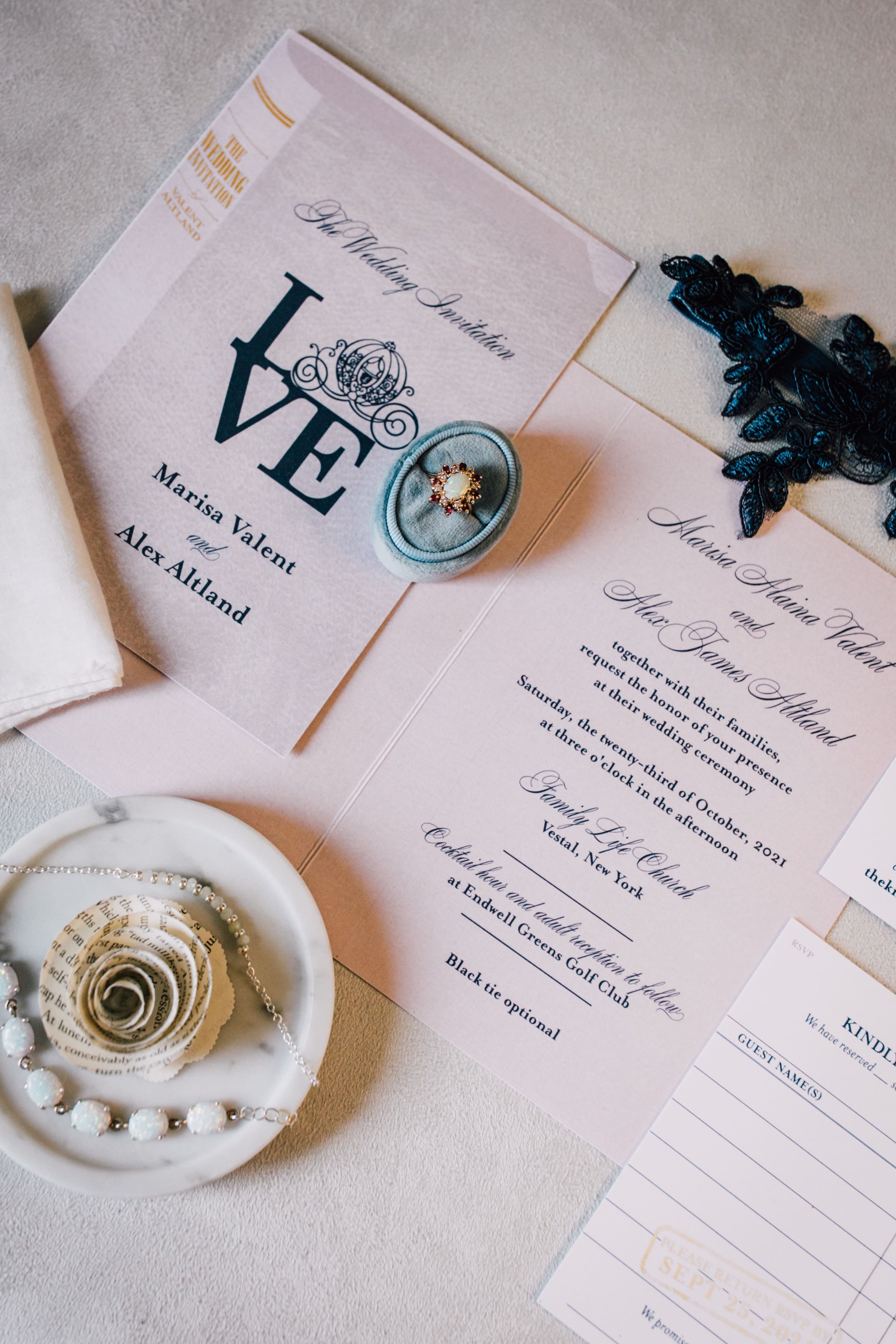  a flatlay of a invitation suite from a library-themed wedding shot from an angle including a library card rsvp 