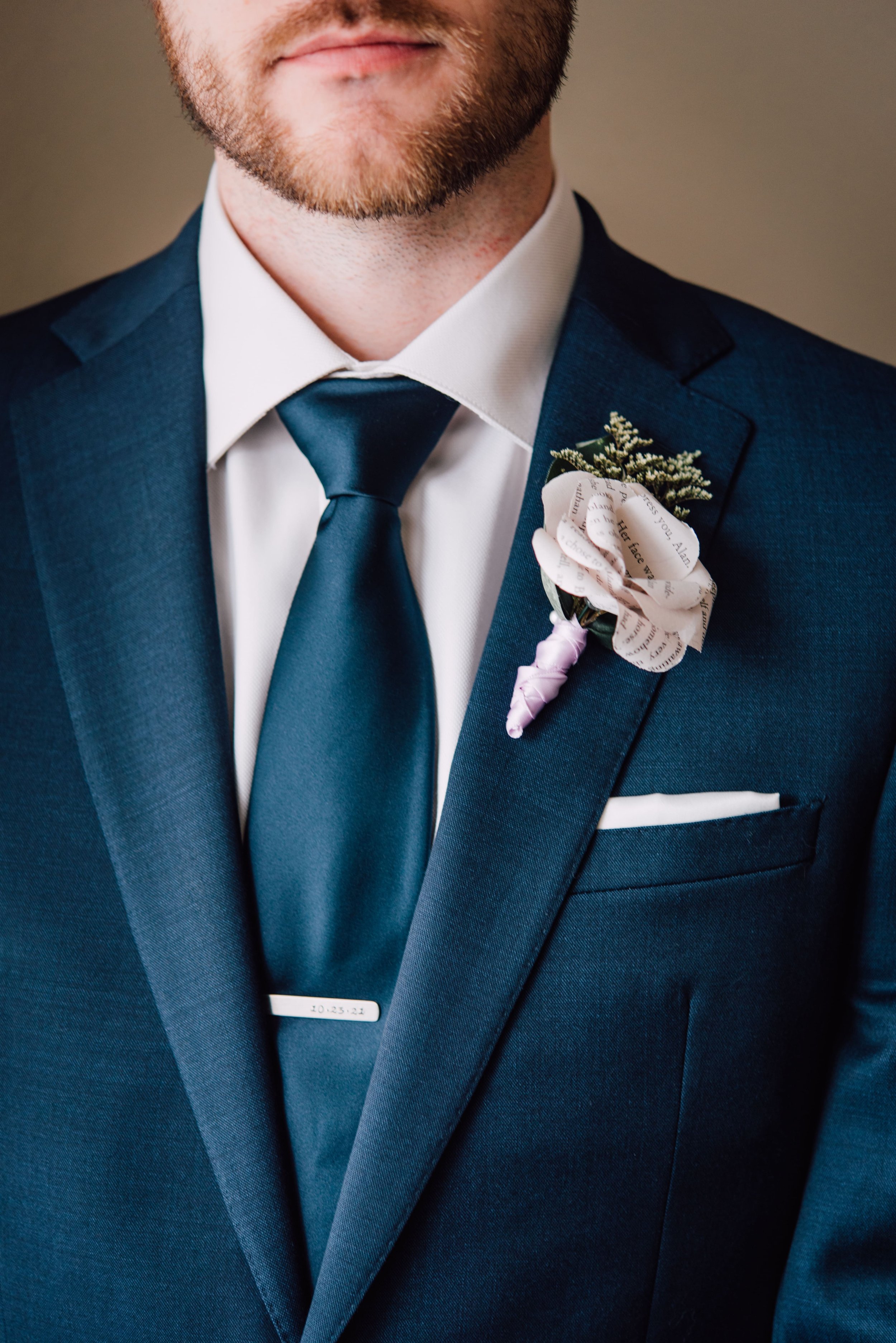  a photo of the grooms paper wedding flowers boutonniere and tie  