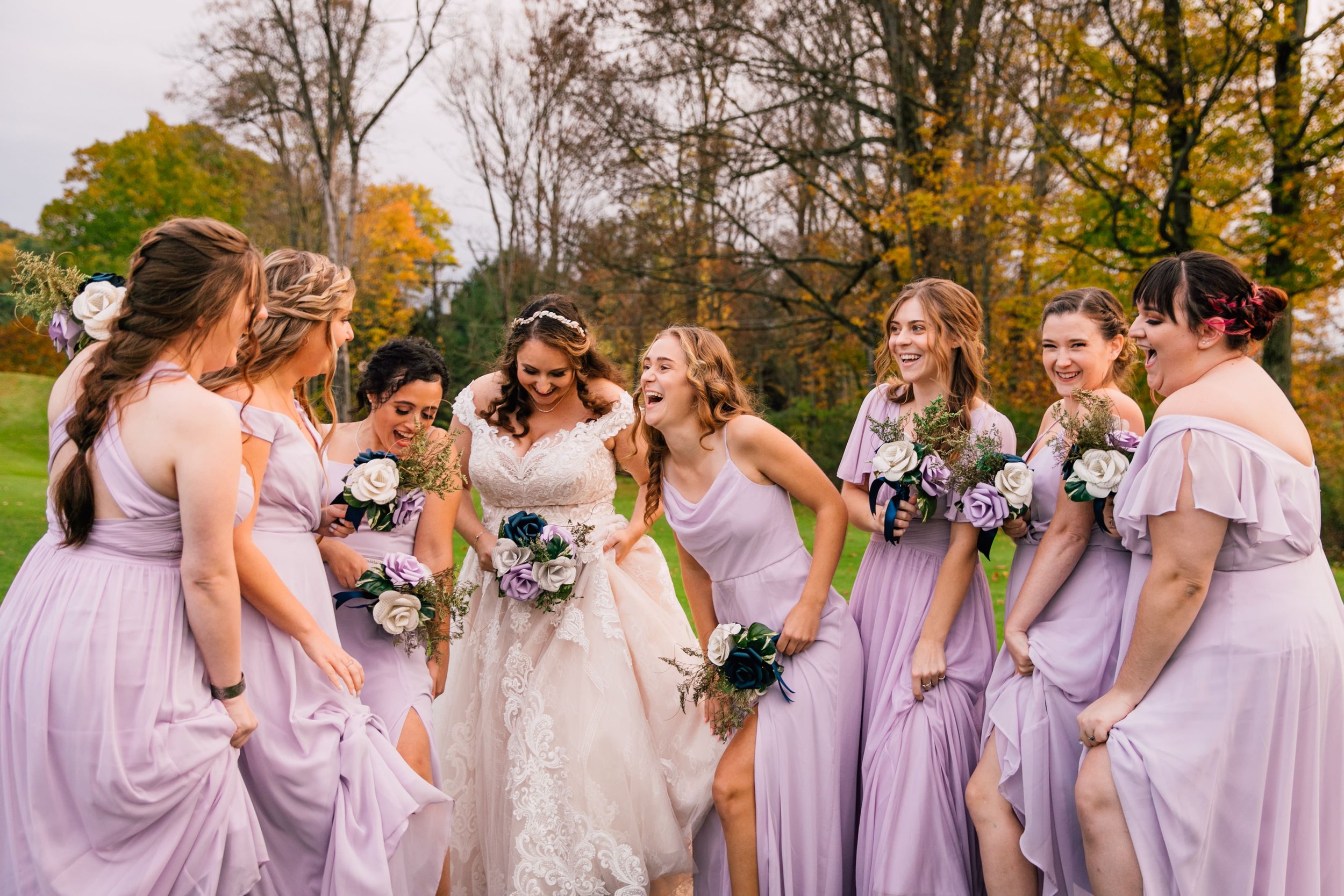  a wedding photographer captures the bride and bridesmaids laughing together at a fall wedding 