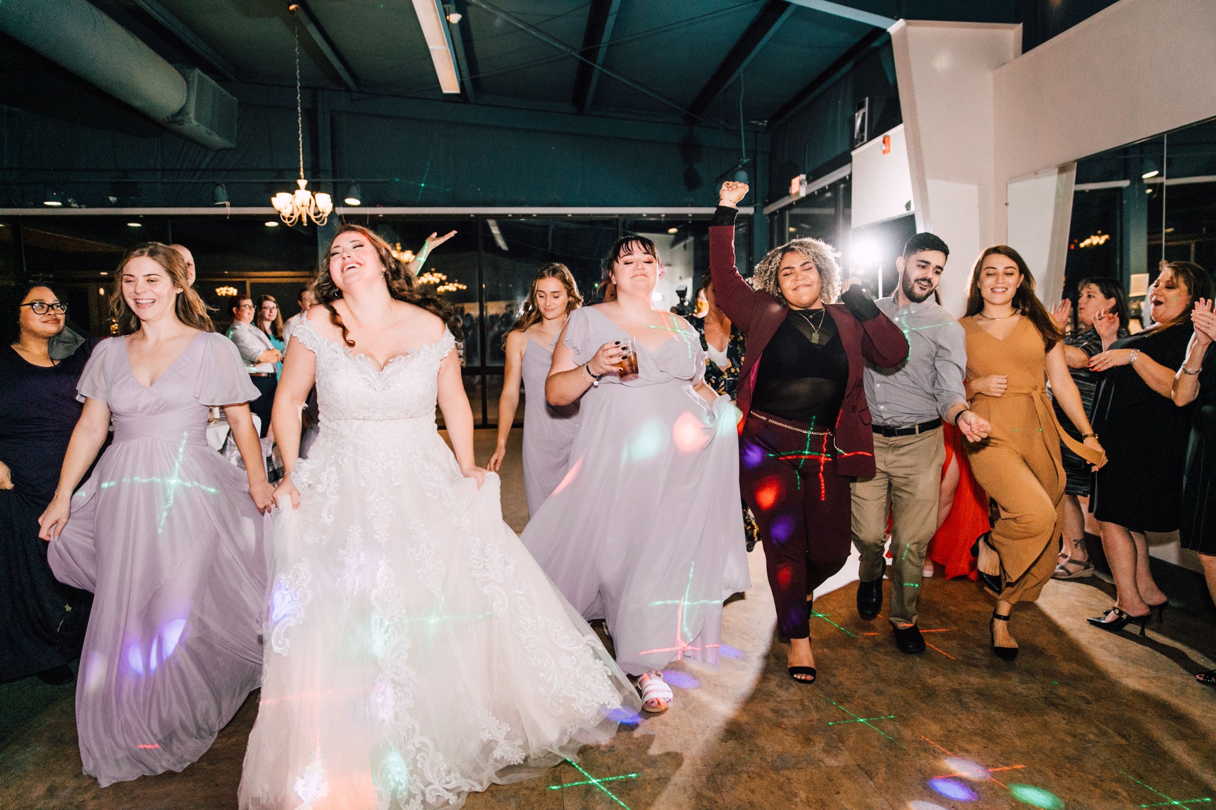  the bride dances with her bridesmaids during her library wedding reception in Endwell, NY 