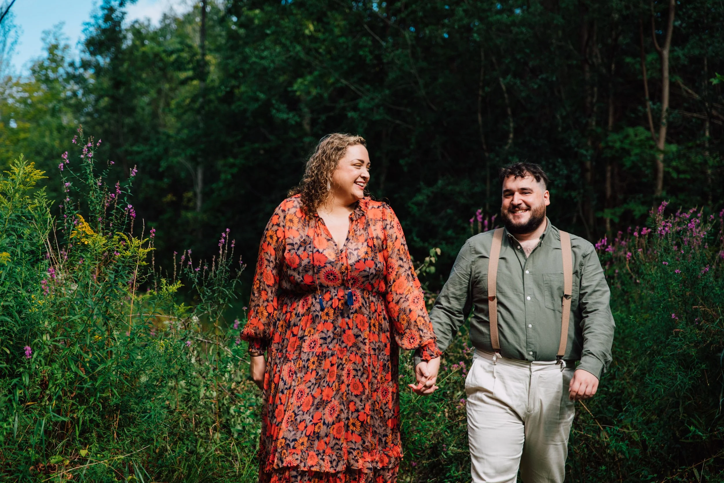  engaged couple stand among wildflowers at rice creek field station for their engagement photoshoot 