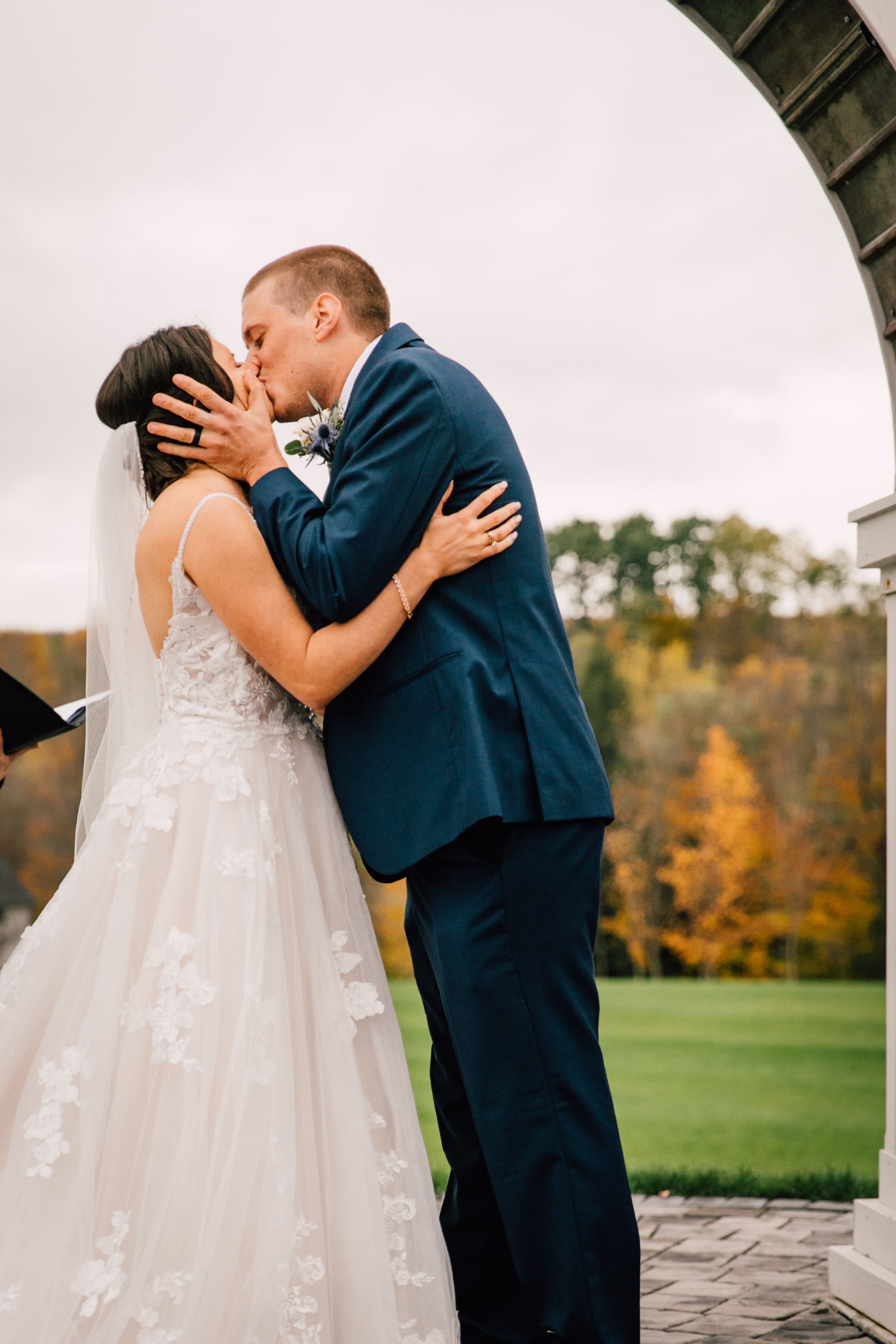  the bride and groom share their first kiss during their outdoor fall wedding 