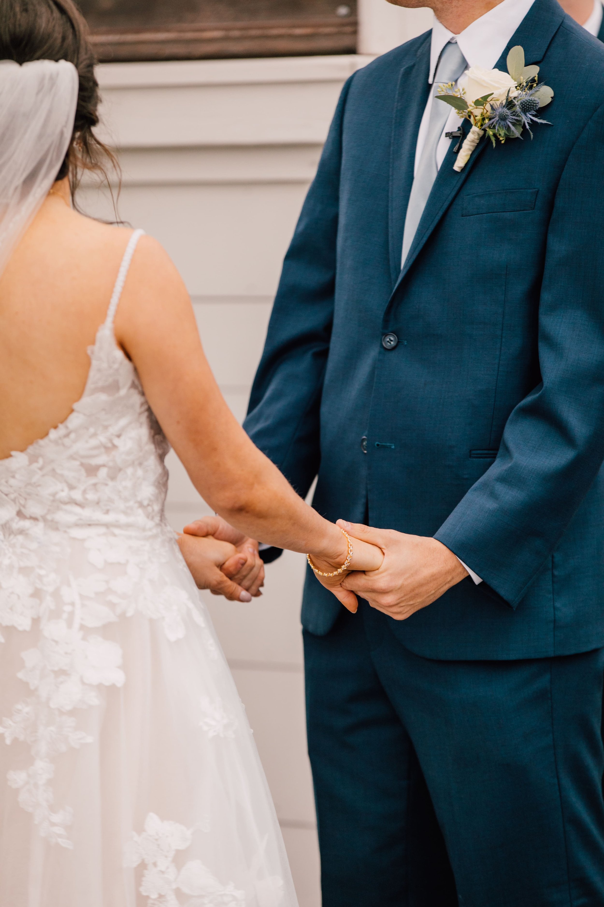  a closeup of the bride and groom while they hold hands during their rustic fall wedding ceremony 