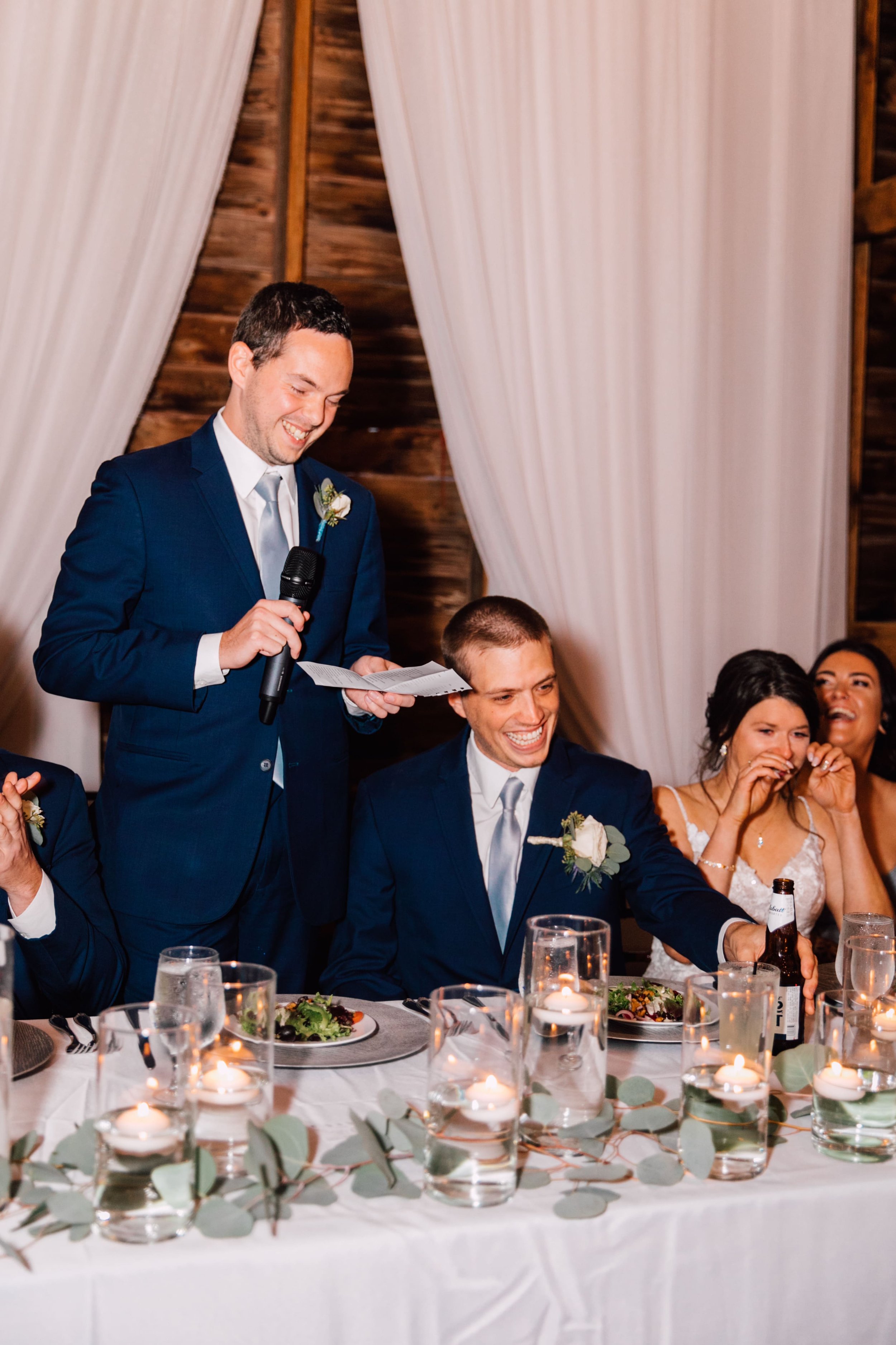  the best man gives a toast as the bride and groom get emotional at their rustic fall wedding 