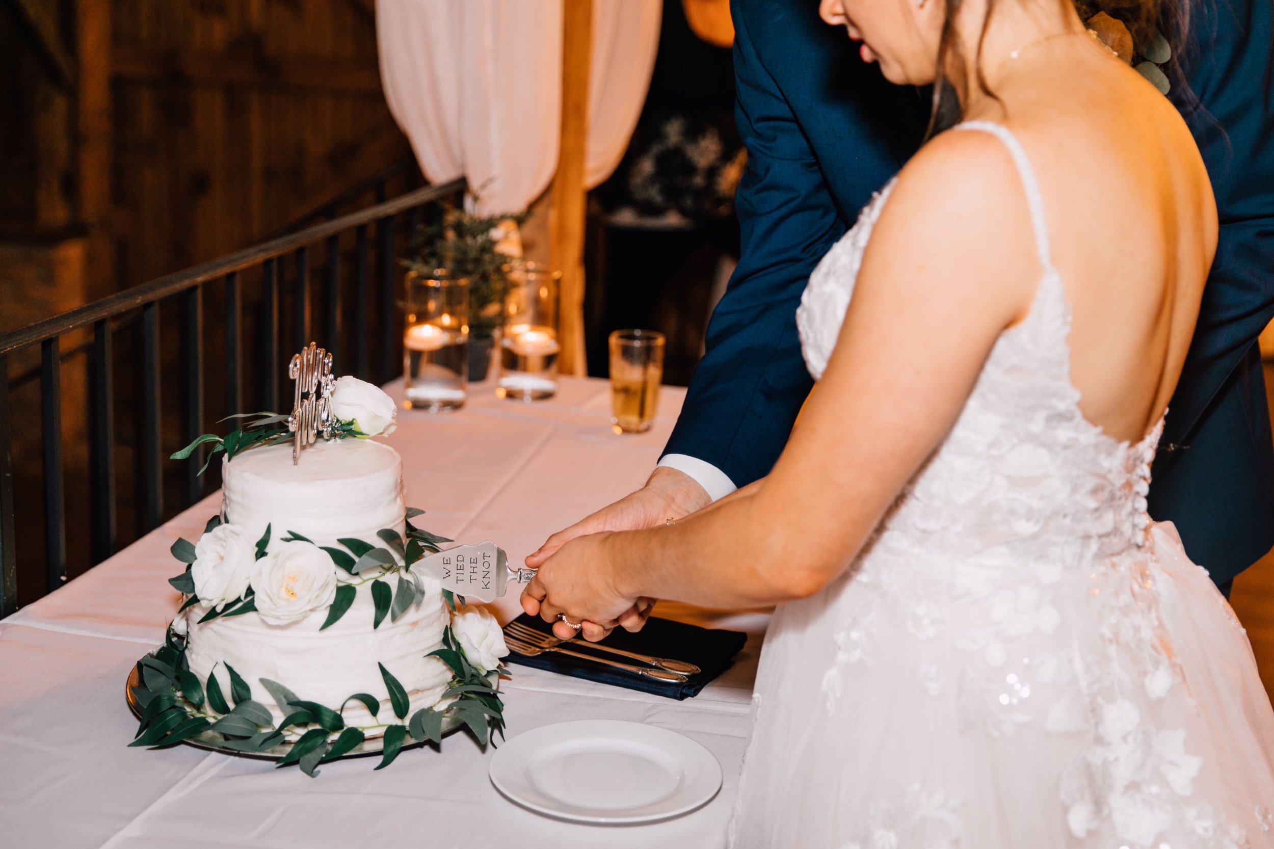  the bride and groom cut their wedding cake at their elegant barn wedding 