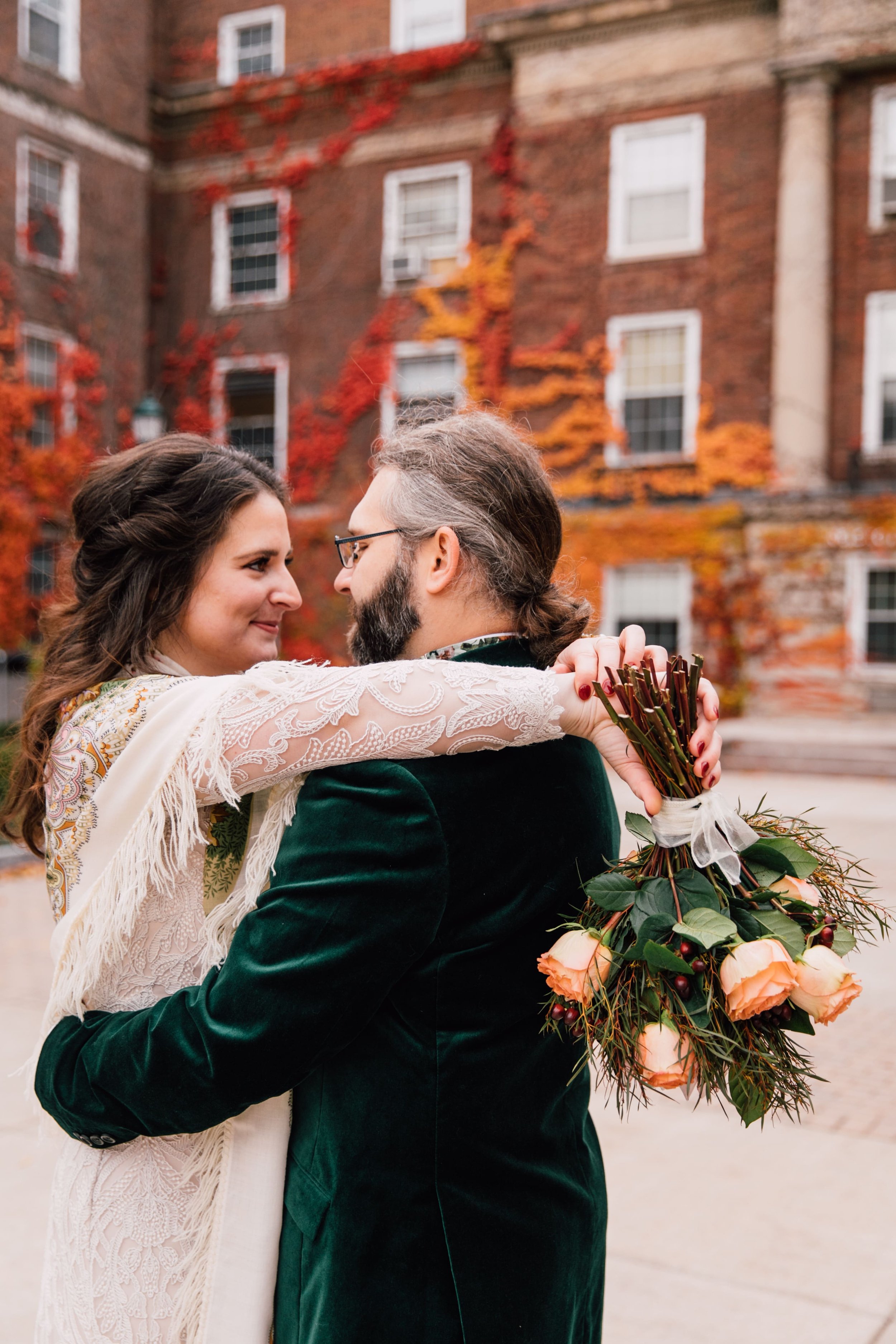  Syracuse Wedding Photographer captures fall wedding portraits as they bride and groom look each other in the eye the bride rests her arms on the grooms shoulders while holding her bouquet upside down 