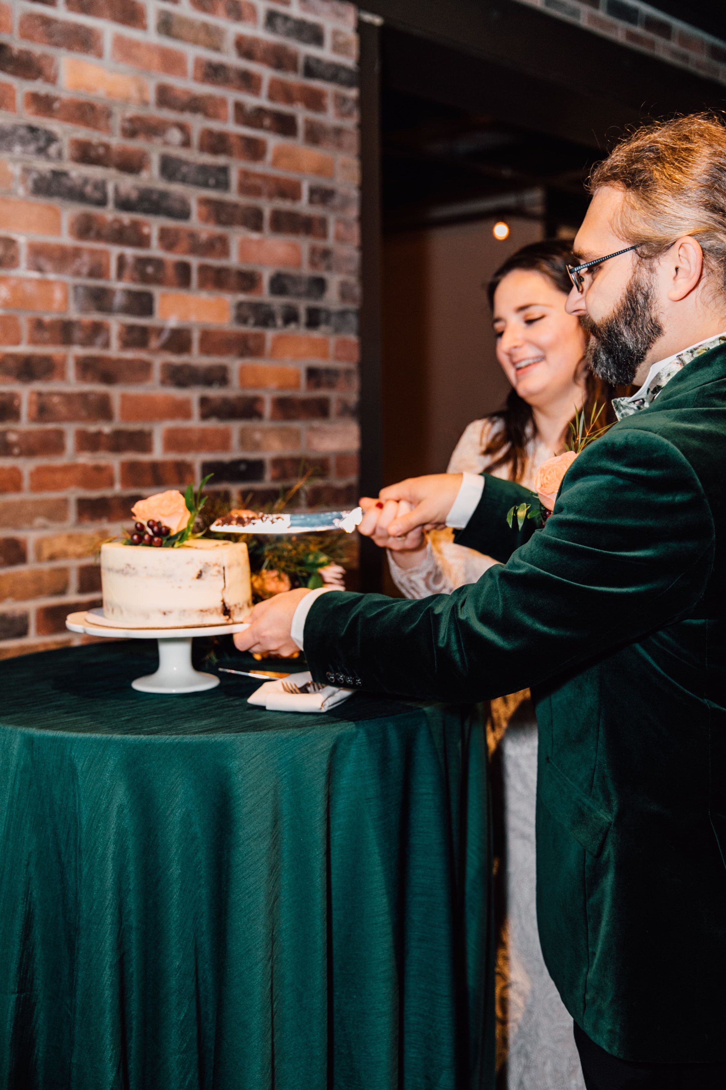  syracuse wedding photographer captures the newlyweds cutting into their wedding cake 
