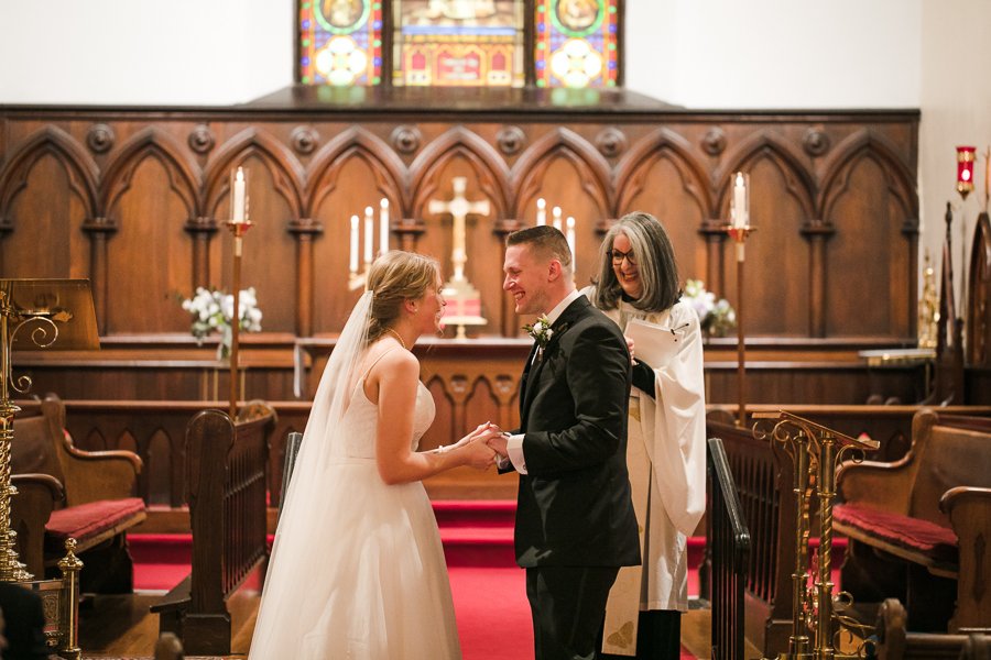  Bride and Groom smile at each other after being pronounced married during church wedding ceremony 