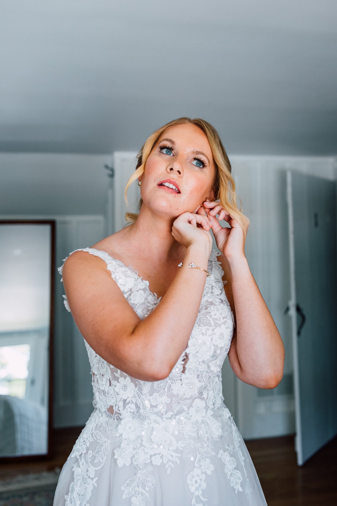  Bride puts on her earrings before her intimate barn wedding in Central NY   